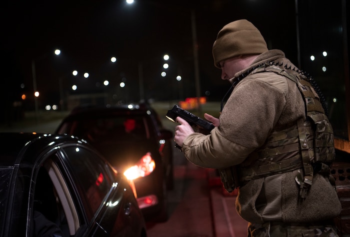 Gate guard checks I.D. at night