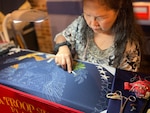 woman embroiders flag