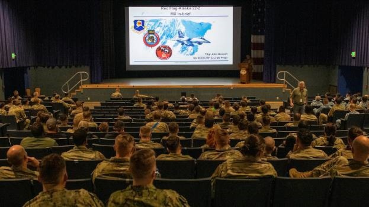 U.S. Air Force Tech. Sgt. John Beckett, Red Flag 22-2 Maintenance Group project officer, addresses visiting participants during a welcome briefing at the base theater, as part of Red Flag Exercise 22-2, at Eielson Air Force Base, Alaska, June 9, 2022. Red Flag-Alaska is designed to provide realistic training essential to the success of air and space operations in a simulated combat environment and is held multiple times per year with participants from all branches of U.S. military forces, alongside allied and partner forces. (U.S. Air Force photo by Staff Sgt. Ryan Lackey)