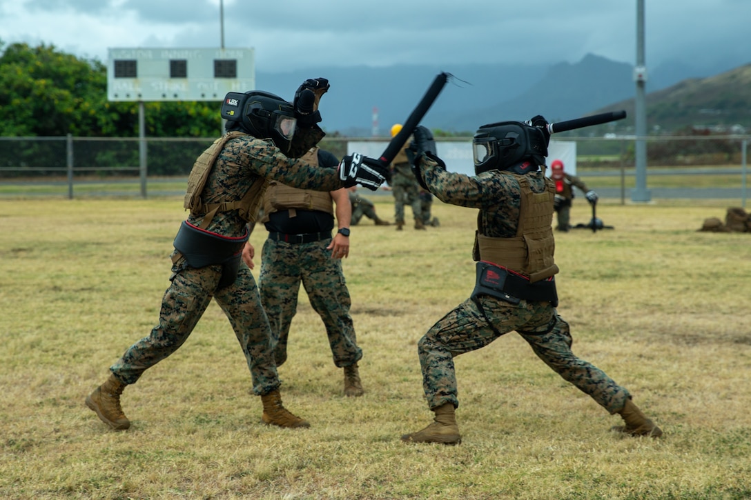 U.S. Marines spar with training weapons during the culminating event of a Martial Arts Instructor course on Marine Corps Base Hawaii, May 5, 2022. MAI courses certify Marines to instruct and monitor Marine Corps Martial Arts Program training and advance Marines in belt levels. MCMAP is a synergy of mental, character, and physical disciplines, and in concert with Marine Corps leadership principles, training in these three disciplines enhances the Marine both on and off the battlefield.