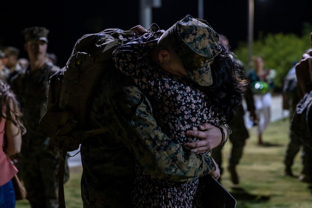 U.S. Marine Corps Cpl. Jarod Ludwig, an infantry rifleman with Company F, 2nd Battalion, 7th Marine Regiment, 1st Marine Division, hugs a family member during a homecoming ceremony at Marine Corps Air Ground Combat Center, Twentynine Palms, California, April 13, 2022. The unit returned to the Combat Center after completing a unit deployment program to Okinawa, Japan with the 3rd Marine Division. (U.S. Marine Corps photo by Lance Cpl. Joshua Sechser)