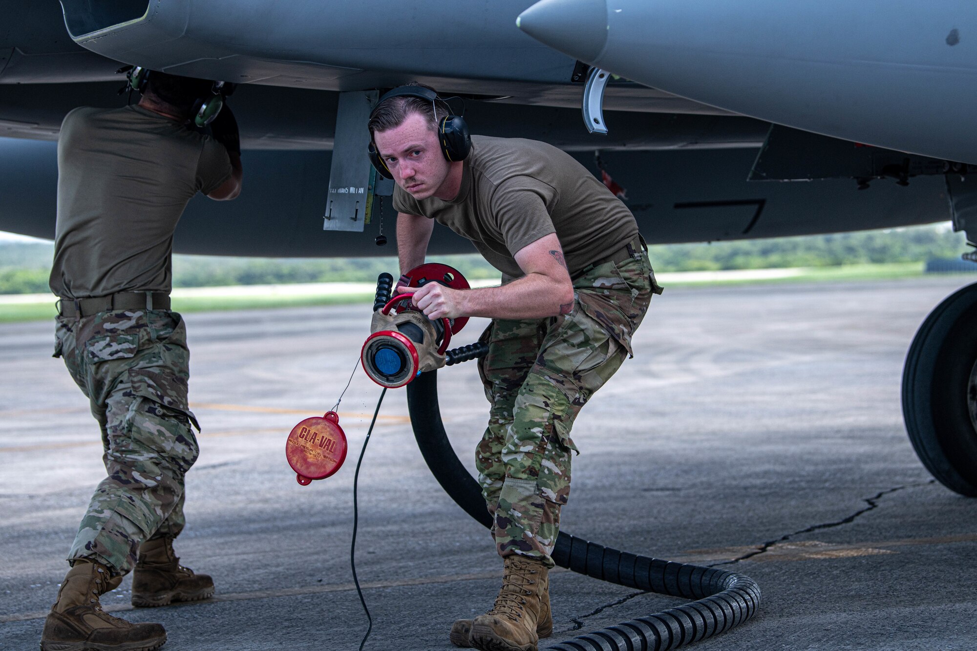 An Airman carries a hose.