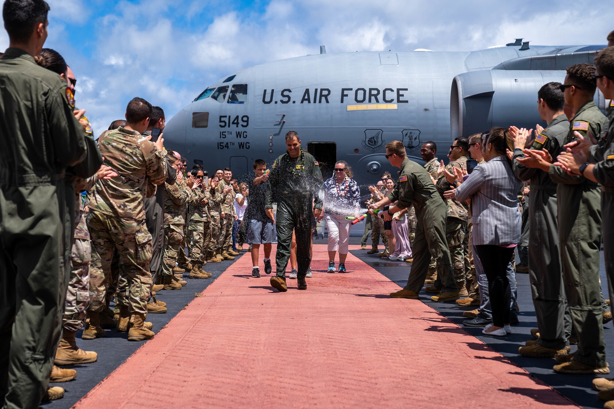 Col. Daniel Dobbels, 15th Wing commander, celebrates with his family and team members after flying his final flight on a C-17 Globemaster III at Joint Base Pearl Harbor-Hickam, Hawaii, June 15, 2022. The fini-flight tradition began during World War II signifying an important milestone, the tradition continues today. (U.S. Air Force photo by Airman 1st Class Makensie Cooper)