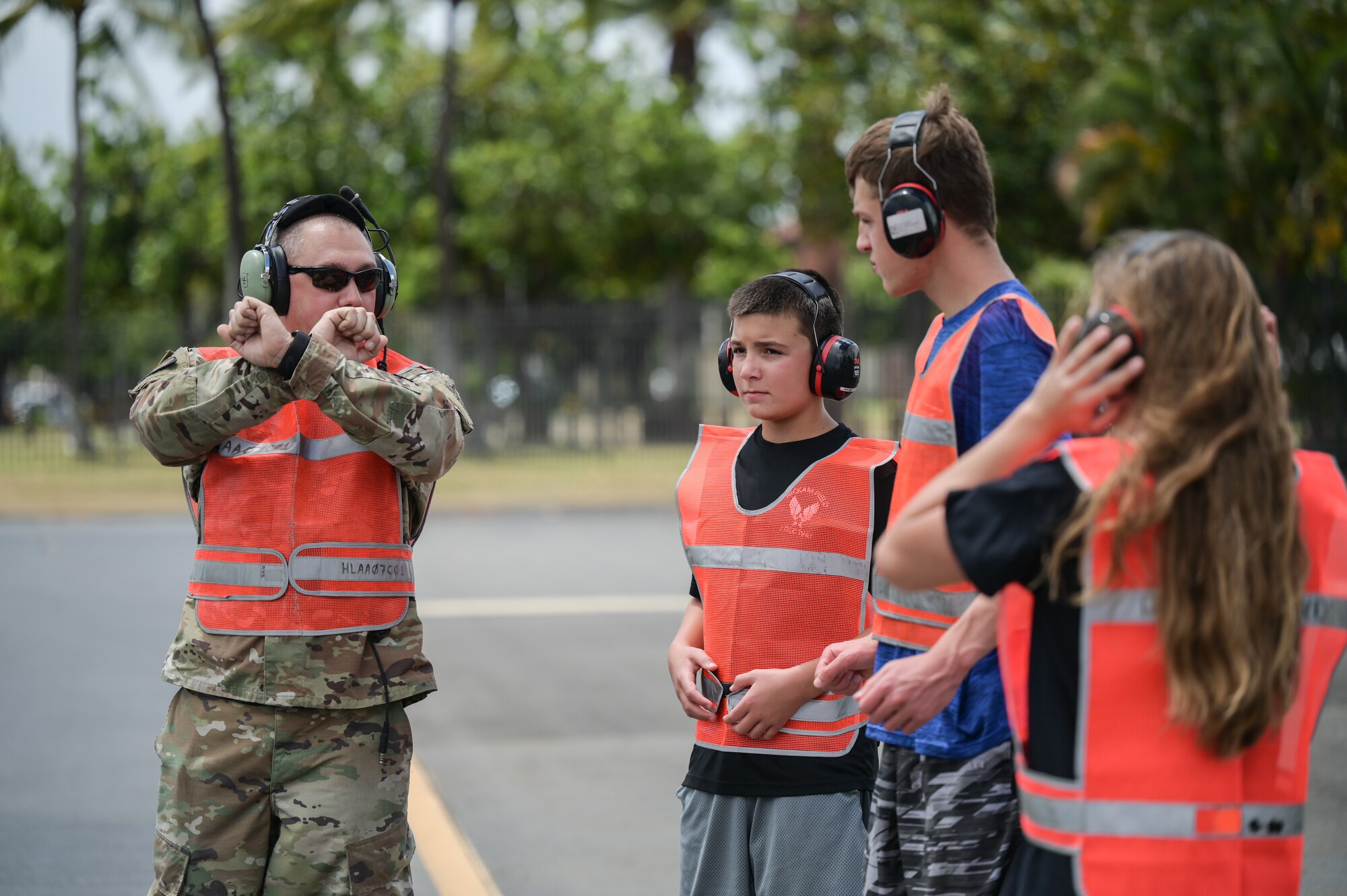 The children of Col. Daniel Dobbels, 15th Wing commander, are instructed on how to marshal an aircraft during their father’s fini-flight ceremony on Hickam Field at Joint Base Pearl Harbor-Hickam, Hawaii, June 15, 2022. The fini-flight began as an aviator’s tradition in World War II, signifying a pilot’s retirement, departure, or final flight of a specified aircraft. (U.S. Air Force photo by Staff Sgt. Alan Ricker)