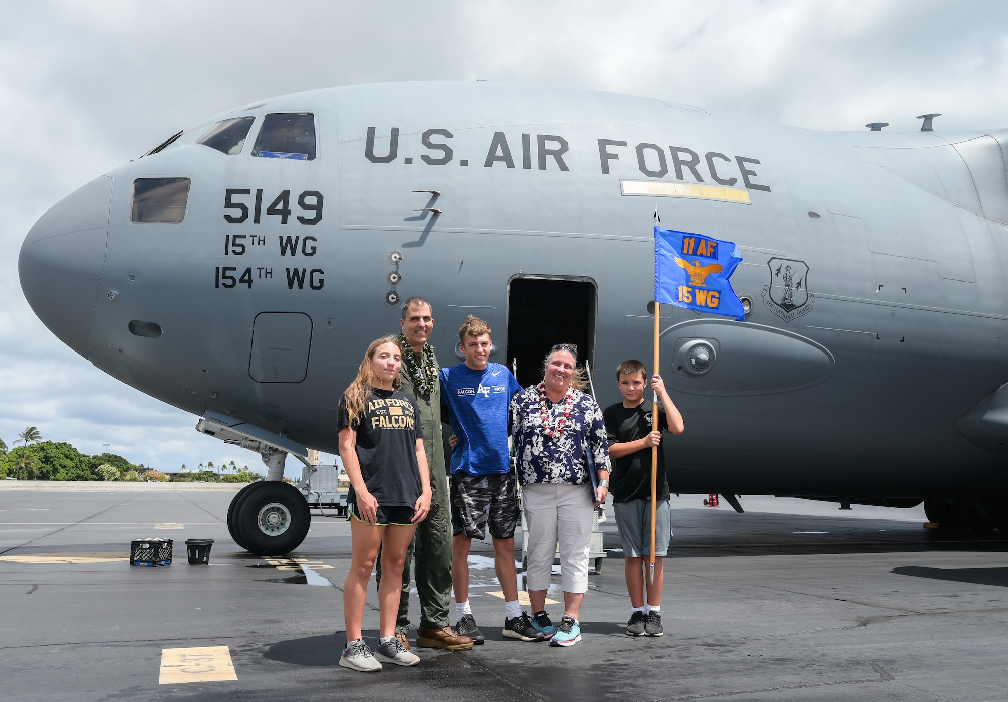 Col. Daniel Dobbels, 15th Wing commander, and his family celebrate together after his final flight on a C-17 Globemaster III at Joint Base Pearl Harbor-Hickam, Hawaii, June 15, 2022. Dobbels and his family celebrated the end of their 24-year-old Air Force journey. (U.S. Air Force photo by Staff Sgt. Alan Ricker)
