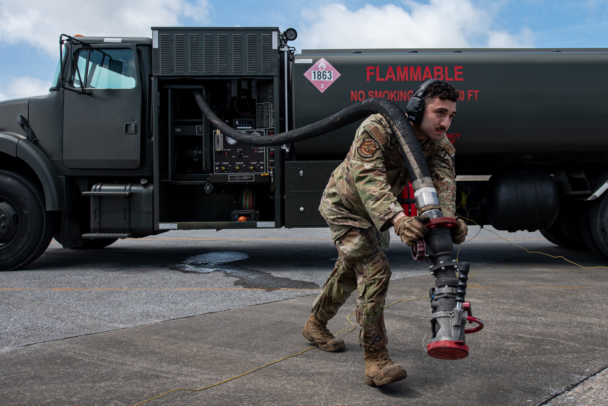 An Airman carries a hose.