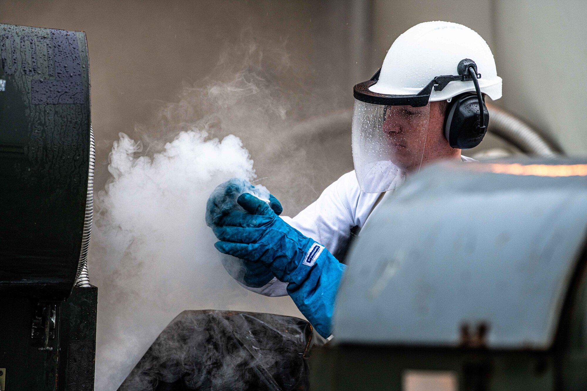 An Airman puts liquid oxygen in a beaker.