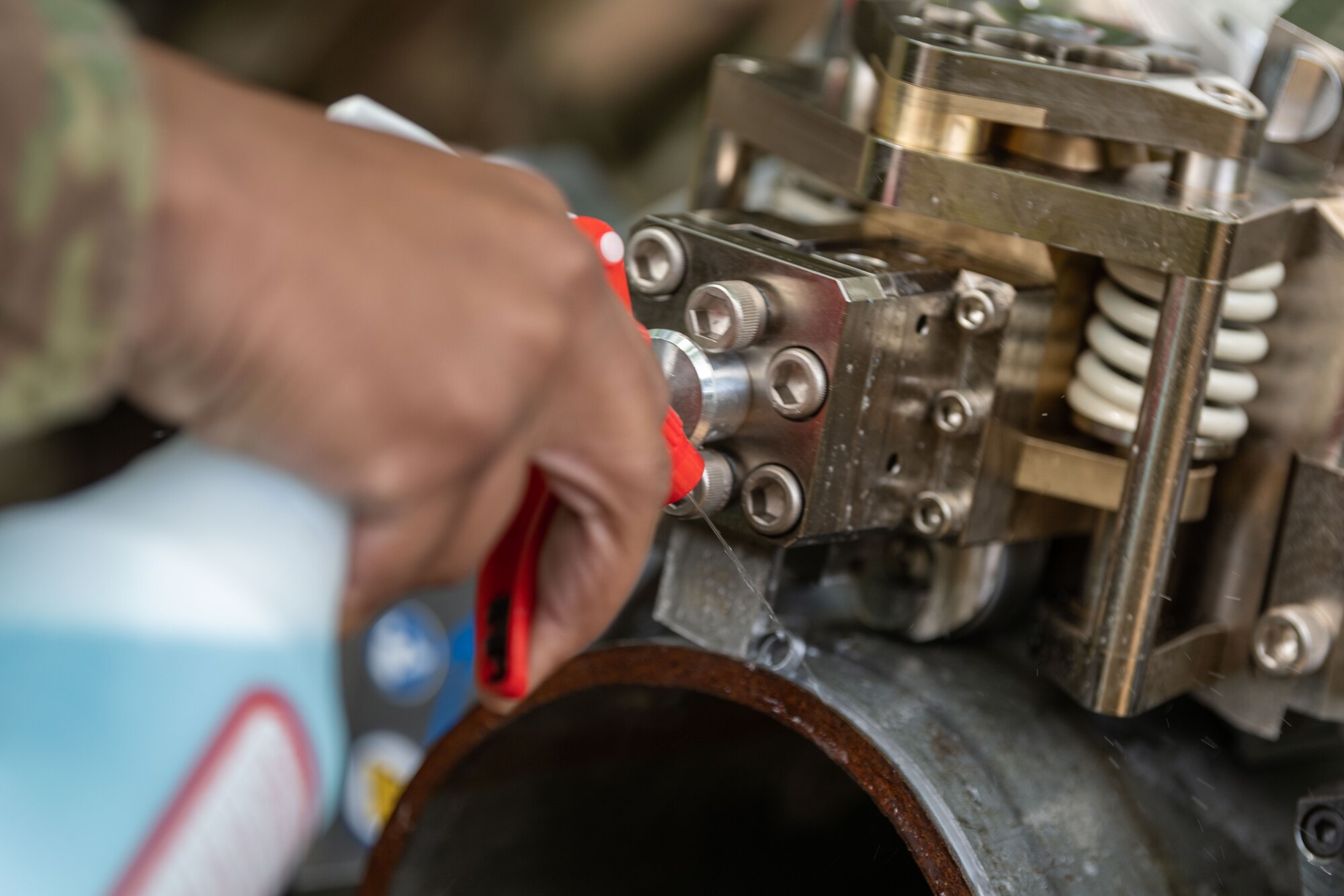 U.S. Airman 1st Class Stefan Ali, 35th Civil Engineer Squadron water and fuel system journeyman, sprays a cutting fluid onto the pipe while the Water and Fuel Expedient Repair System (WaFERS) cuts during an annual Prime Base Engineer Emergency Force (Prime BEEF) training at Misawa Air Base, Japan, June 14, 2022.