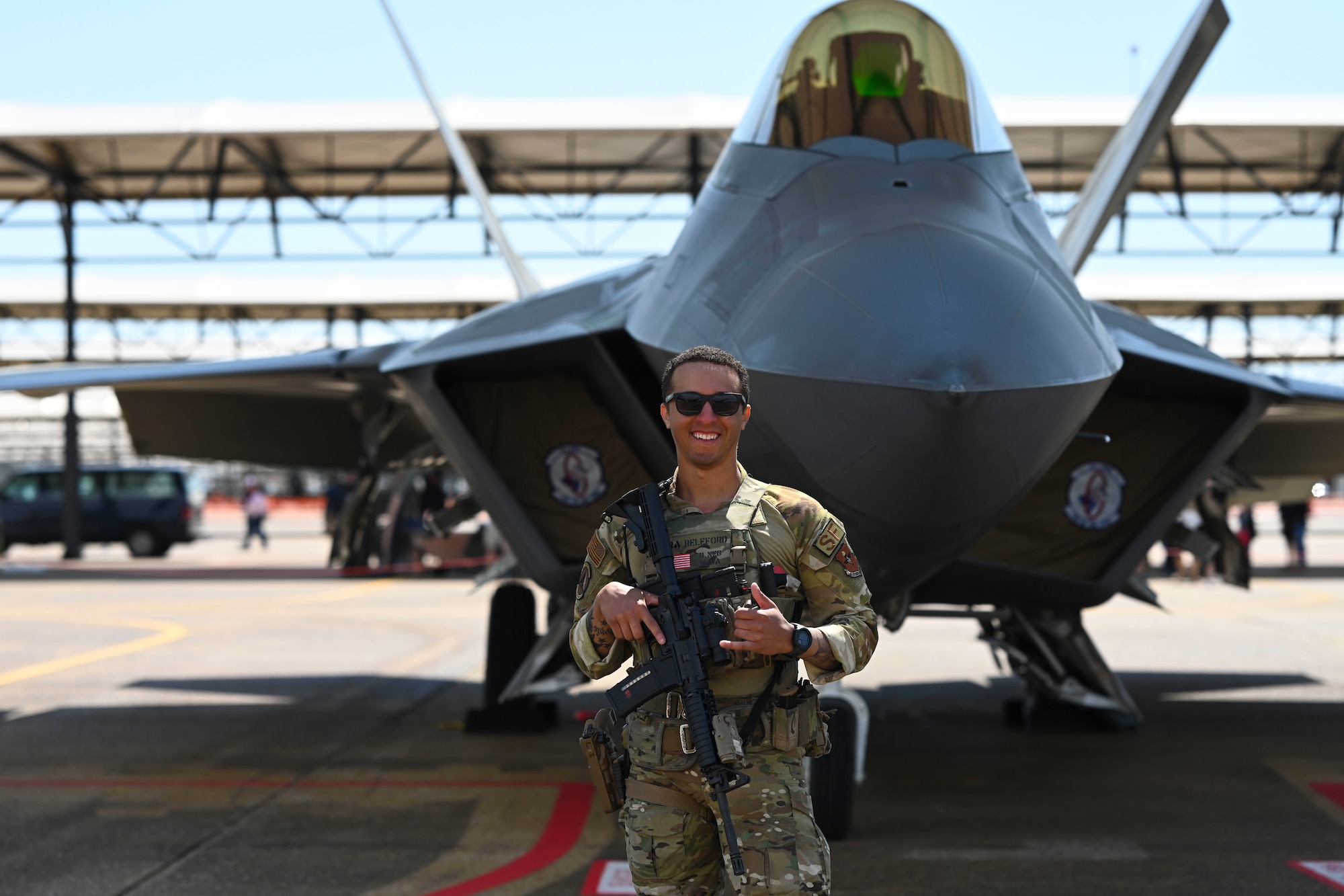 U.S. Air Force Senior Airman Tarriq Releford, 14th Security Forces Squadron, installation entry controller, stands guard in front of an F-22 Raptor, during the Wings over Columbus Air Show, Mar. 26, 2022, on Columbus Air Force Base, Miss. Releford was one of four Airmen who was selected to attend a 53-day Army Sniper School this past April. (U.S. Air Force photo by Airman 1st Class Jessica Haynie)