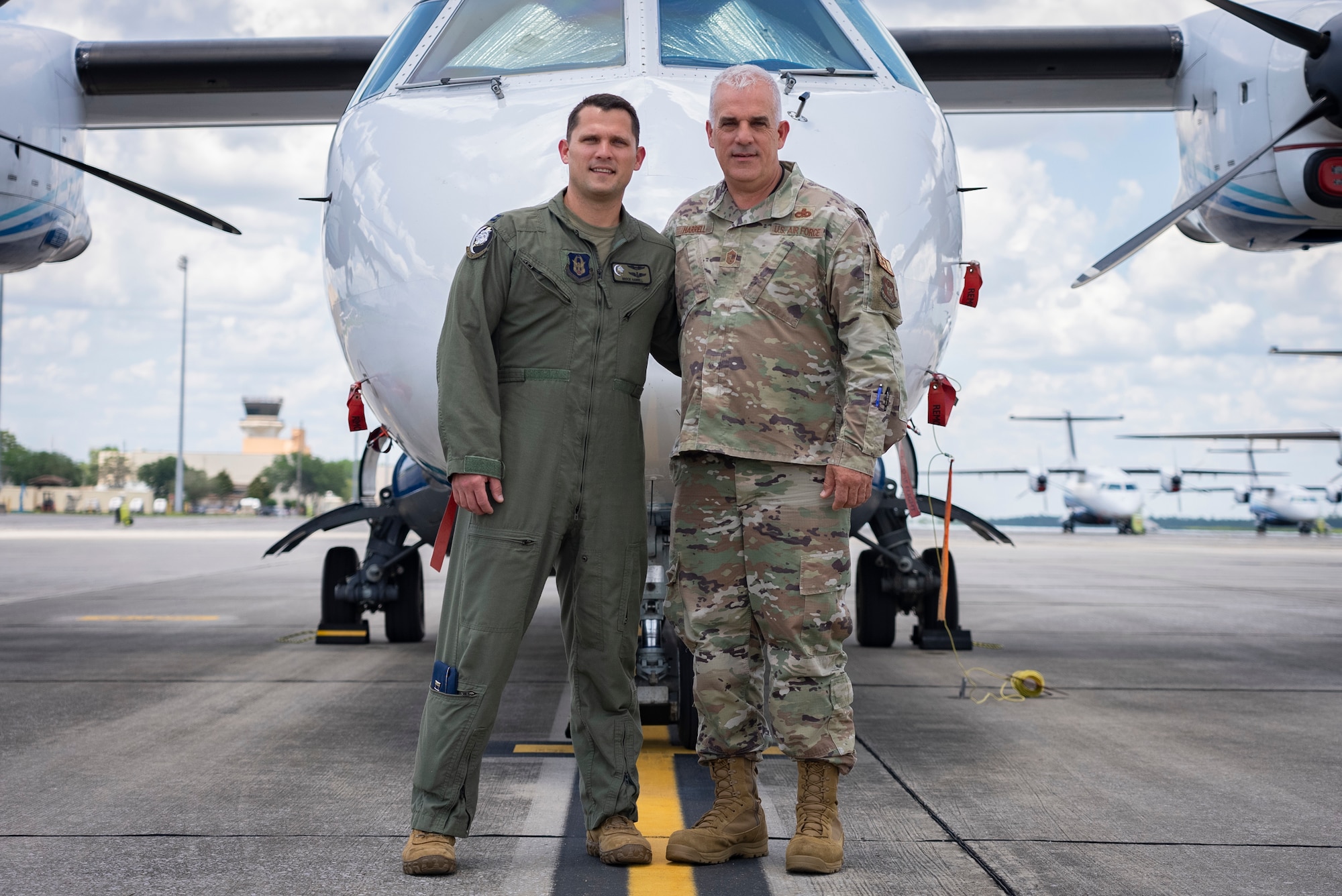 Father and son take a moment to pose for a photo in front of an aircraft at Duke Field, Fla.