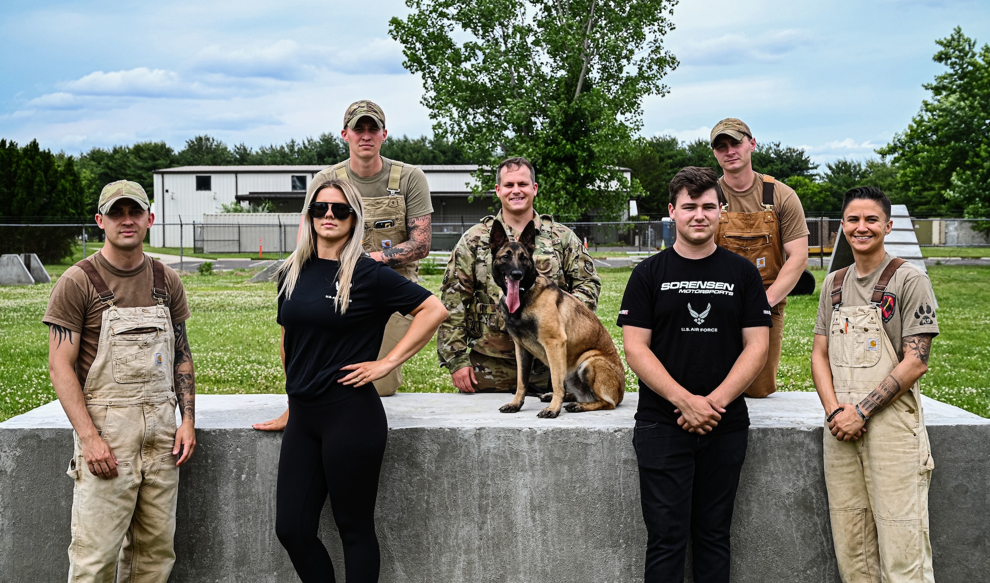 Formula Drift drivers Branden and Amanda Sorenson pose for a group photo with Airman from the Military Working Dog kennel, 87th Security Forces Squadron at Joint Base McGuire-Dix-Lakehurst on June 7, 2022. Drift team duo Branden and Amanda Sorensen visited JB MDL to interact with Airmen and learn about different Air Force career fields. Air Force Recruiting Service recently continued their 13-year partnership with the Formula Drift series. Throughout the 2022 Formula Drift circuit, the Air Force will serve as the primary sponsor for the Sorensen Motorsports team.