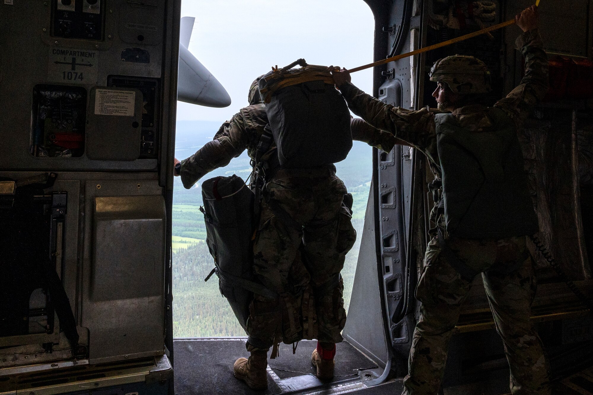 U.S. Army Sgt. 1st Class Charlie Arrendale, looks out the door as they prepare to jump from a C-17 Globemaster III from the 517th Airlift Squadron over Allen Army Airfield, Fort Greely, Alaska, June 15, 2022. RF-A provides realistic combat training by integrating joint, coalition and multilateral forces into simulated forward operating bases. Arrendale is assigned to the 3rd Battalion, 509th Infantry Regiment, 2nd Infantry Brigade Combat Team (Airborne), 11th Airborne Division. (U.S. Air Force photo by Sheila deVera)