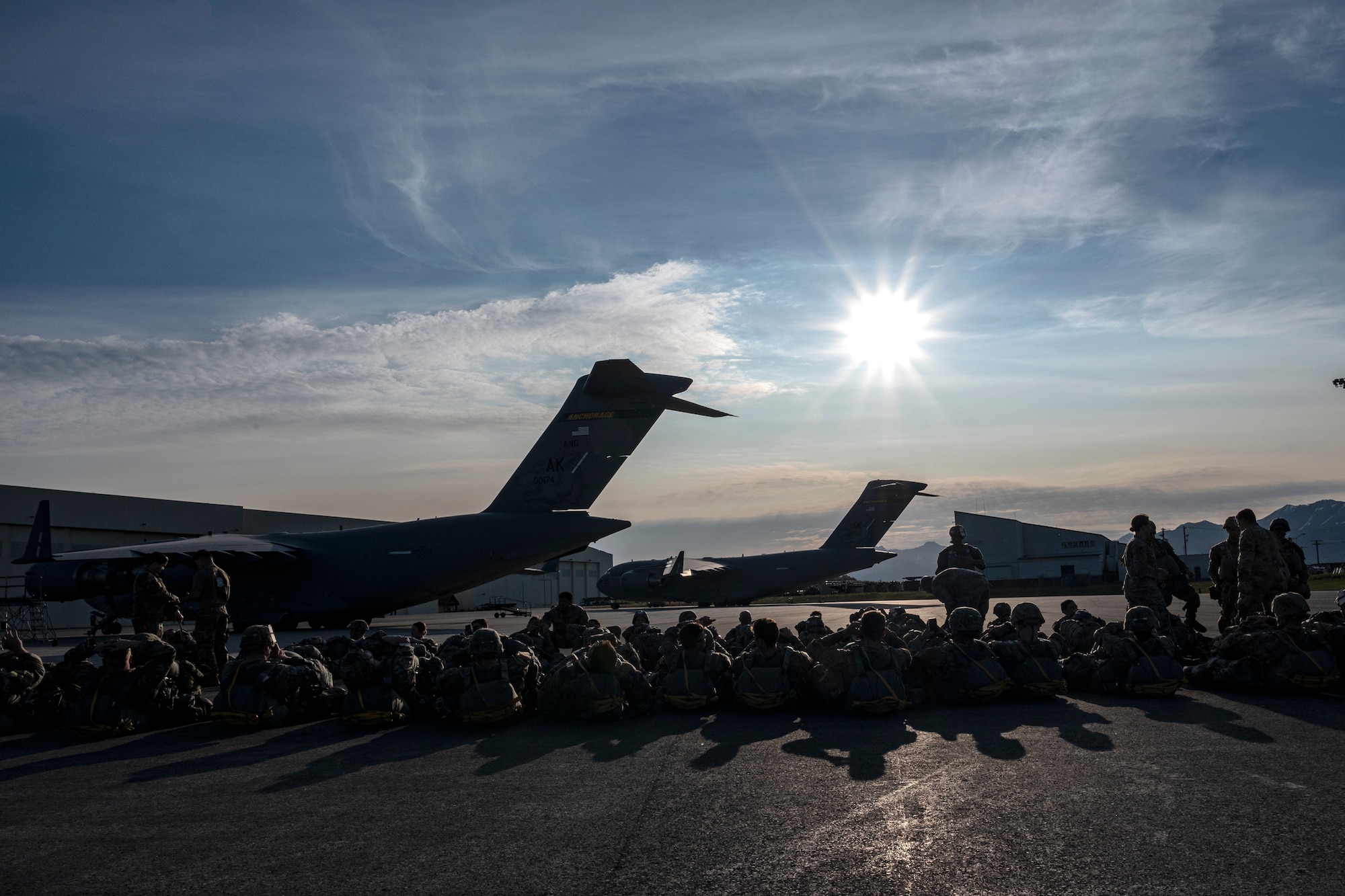 U.S. Army Paratroopers, Air Force joint terminal attack controller and Special Tactic Operators wait on the tarmac before boarding a C-17 Globemaster III from the 517th Airlift Squadron at Joint Base Elmendorf-Richardson, Alaska, June 15, 2022 during RED FLAG-Alaska 22-2. Approximately 1,600 service members from three nations participate in flying, maintaining and supporting more than 70 aircraft from over 22 units during this iteration of exercise. The Paratroopers are assigned to the 2nd Infantry Brigade Combat Team (Airborne), 11th Airborne Division, JTACs are assigned to the 3rd Air Operation Squadron both at JBER and ST operators are assigned to the 23rd Special Tactics Squadron, Hurlburt Field, Florida. (U.S. Air Force photo by Sheila deVera)