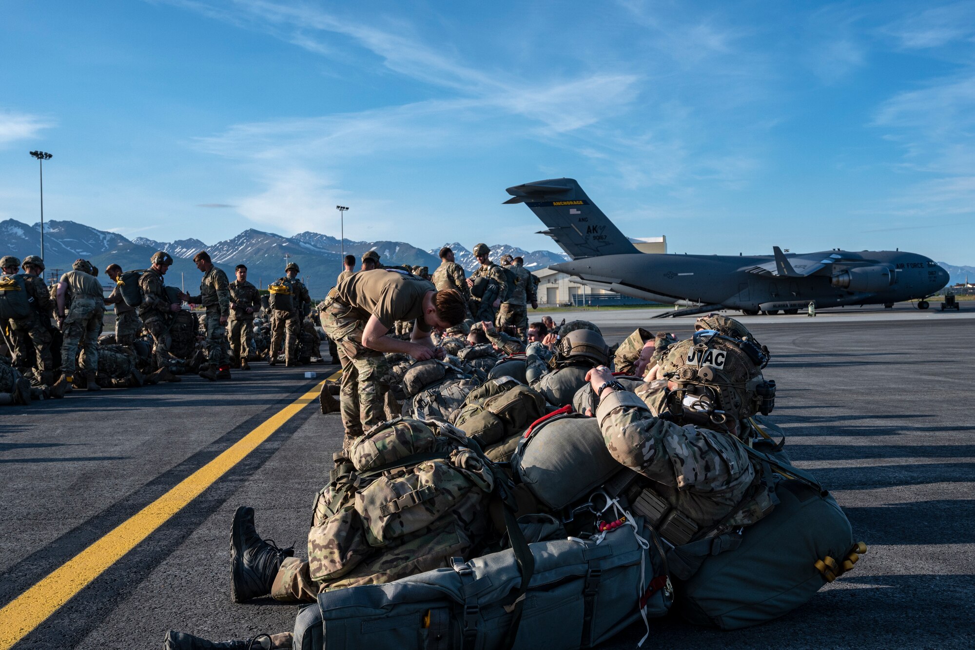 U.S. Army Paratroopers, Air Force joint terminal attack controller and Special Tactic Operators wait on the tarmac before boarding a C-17 Globemaster III from the 517th Airlift Squadron at Joint Base Elmendorf-Richardson, Alaska, June 15, 2022 during RED FLAG-Alaska 22-2. Approximately 1,600 service members from three nations participate in flying, maintaining and supporting more than 70 aircraft from over 22 units during this iteration of exercise. The Paratroopers are assigned to the 2nd Infantry Brigade Combat Team (Airborne), 11th Airborne Division, JTACs are assigned to the 3rd Air Operation Squadron both at JBER and ST operators are assigned to the 23rd Special Tactics Squadron, Hurlburt Field, Florida. (U.S. Air Force photo by Sheila deVera)