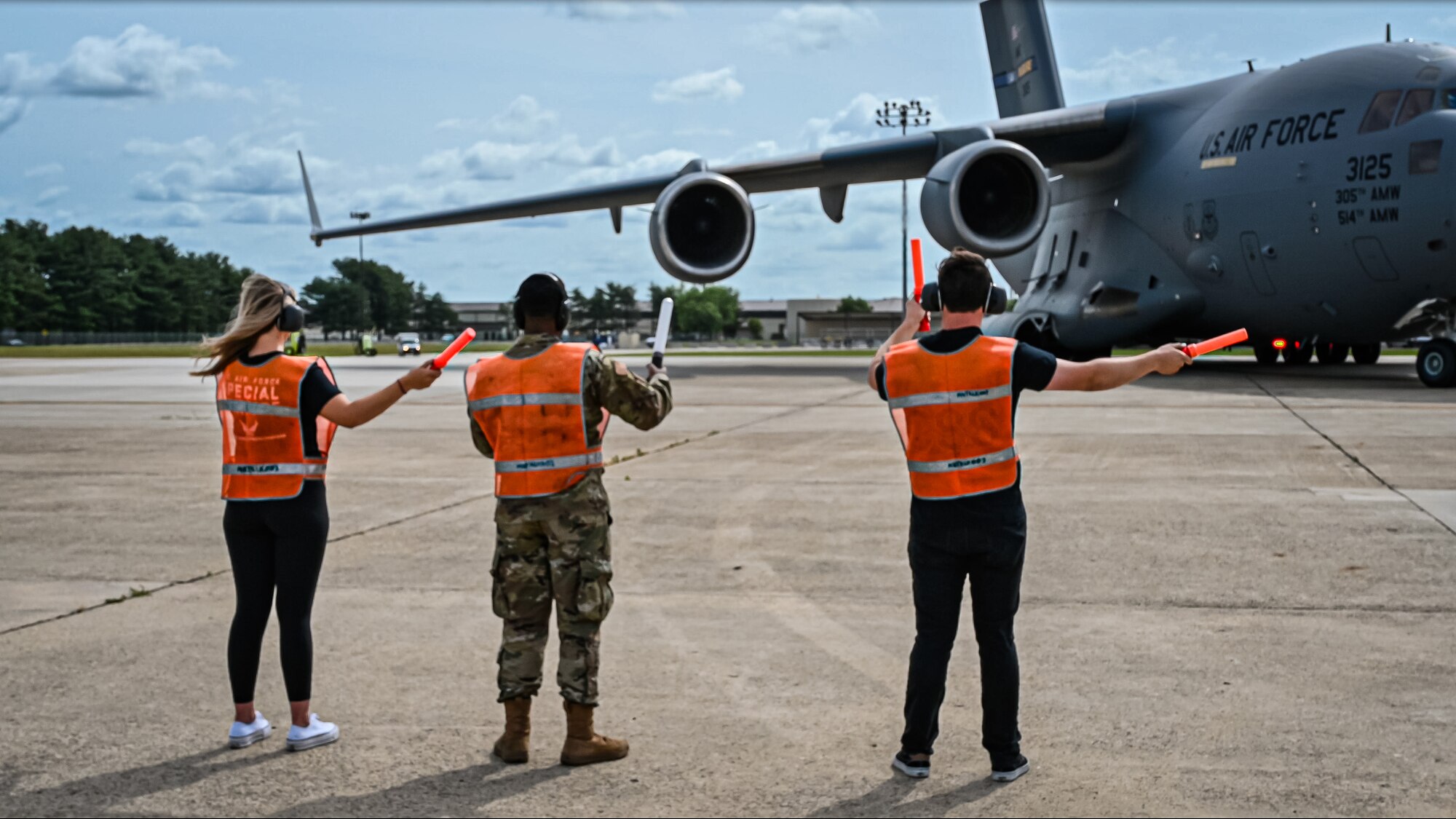 An Airman from the 305th Aircraft Maintenance Squadron and Formula Drift drivers Amanda and Branden Sorenson marshal out a C-17 Globemaster III aircraft at Joint Base McGuire-Dix-Lakehurst on June 7, 2022. Drift team duo Branden and Amanda Sorensen visited JB MDL to interact with Airmen and learn about different Air Force career fields. Air Force Recruiting Service recently continued their 13-year partnership with the Formula Drift series. Throughout the 2022 Formula Drift circuit, the Air Force will serve as the primary sponsor for the Sorensen Motorsports team.