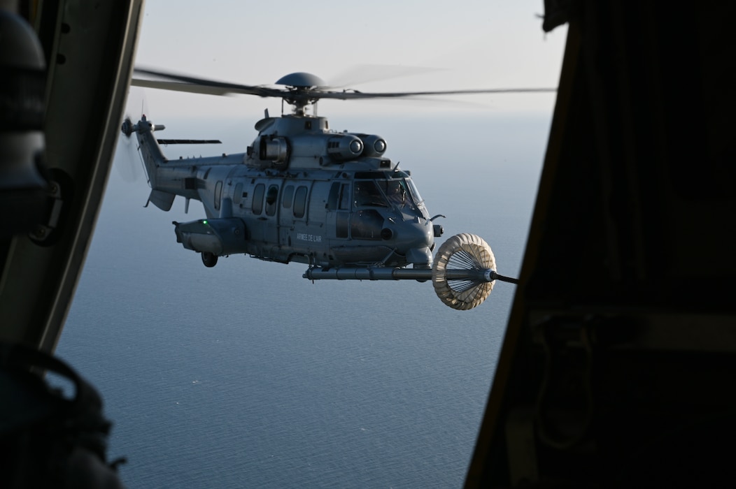 A U.S. Air Force MC-130J Commando II assigned to the 352d Special Operations Wing performs a helicopter air-to-air refueling with an Armée de l'Air et de l’Espace (French Air and Space Force) EC725 Caracal on May 5, 2022.