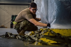 Airman secures netting on cargo