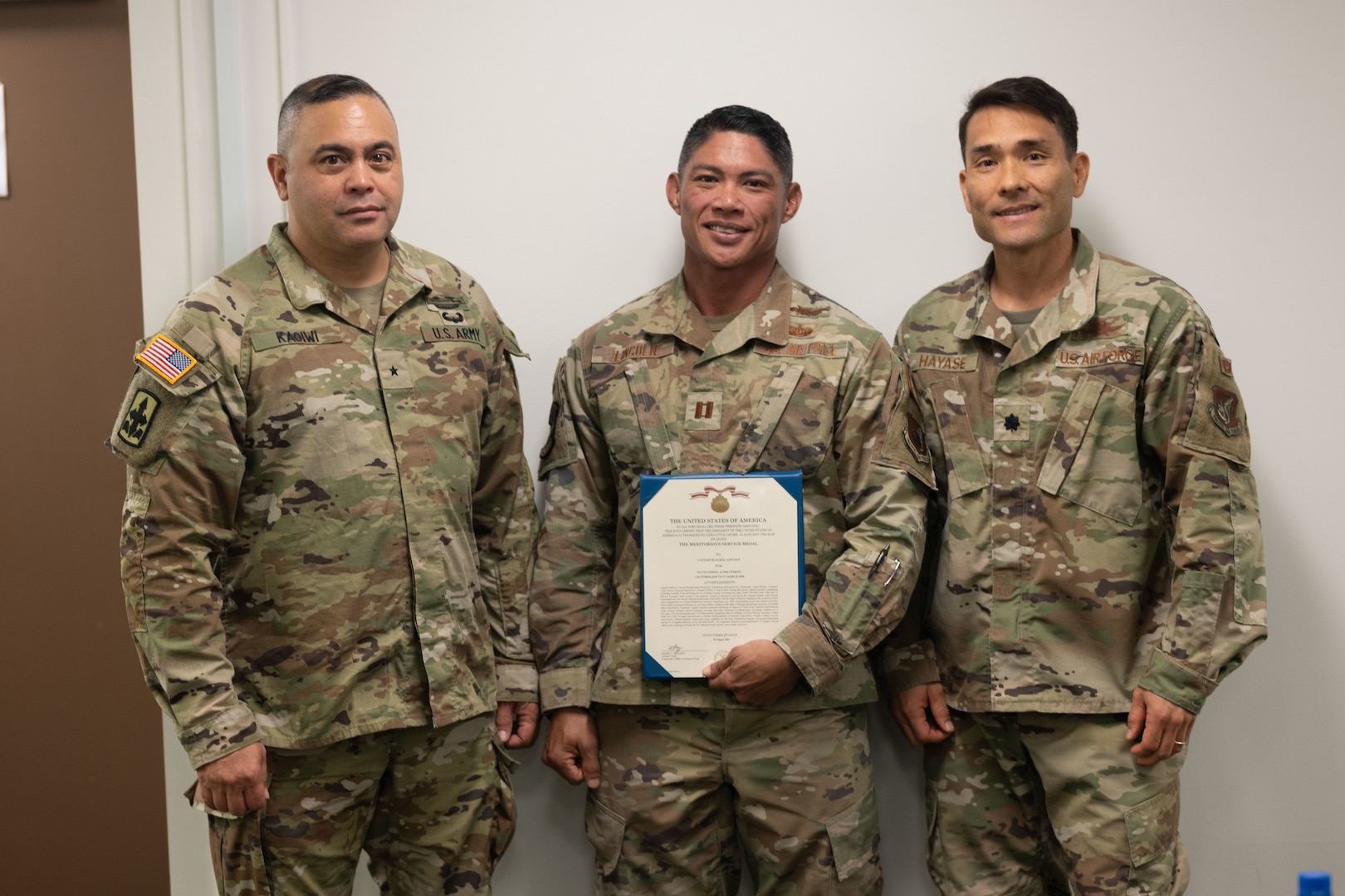 U.S. Air Force Capt. Elijah Lincoln, center, is awarded an achievement medal May 14, 2022, at Fort DeRussy, Hawaii, for standing up the Hawaii National Guard’s first Cyber Mission Assurance Team. With him are U.S. Army Brig. Gen. Moses Kaoiwi Jr., Hawaii Army National Guard commander, and U.S. Air Force Lt. Col. Glen Hayase.