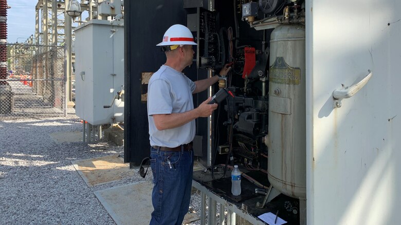 Luke Ditto, Nashville District's Employee of the Month for March, inspects an electrical box at the Old Hickory Power Plant.