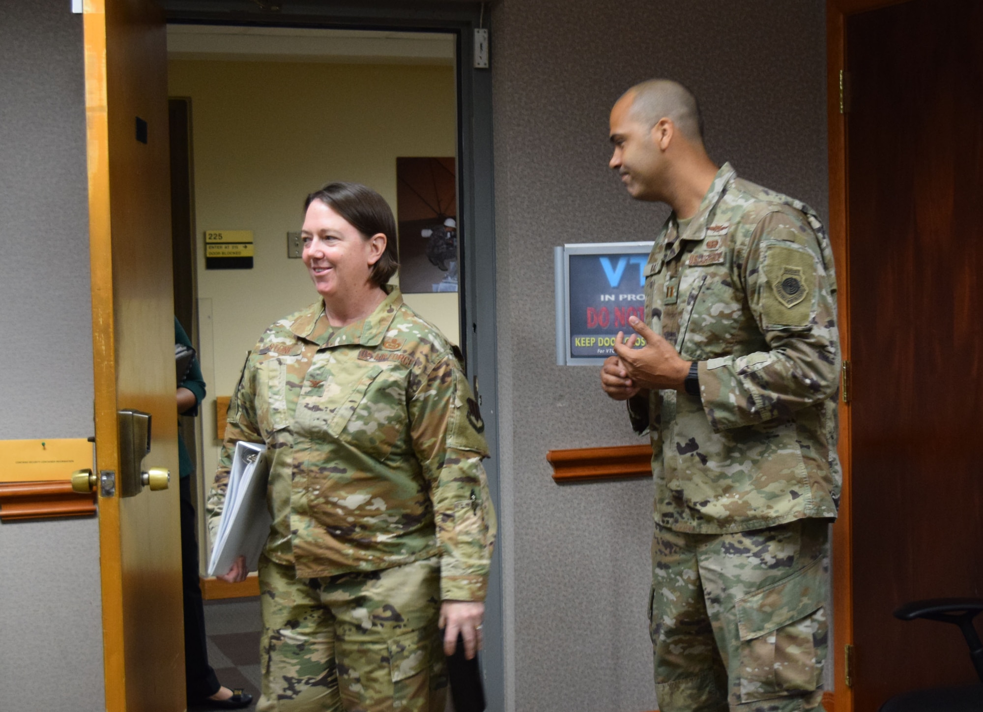 Brig. Gen. (Select) Melissa Stone enters a room with a person in uniform standing by her.