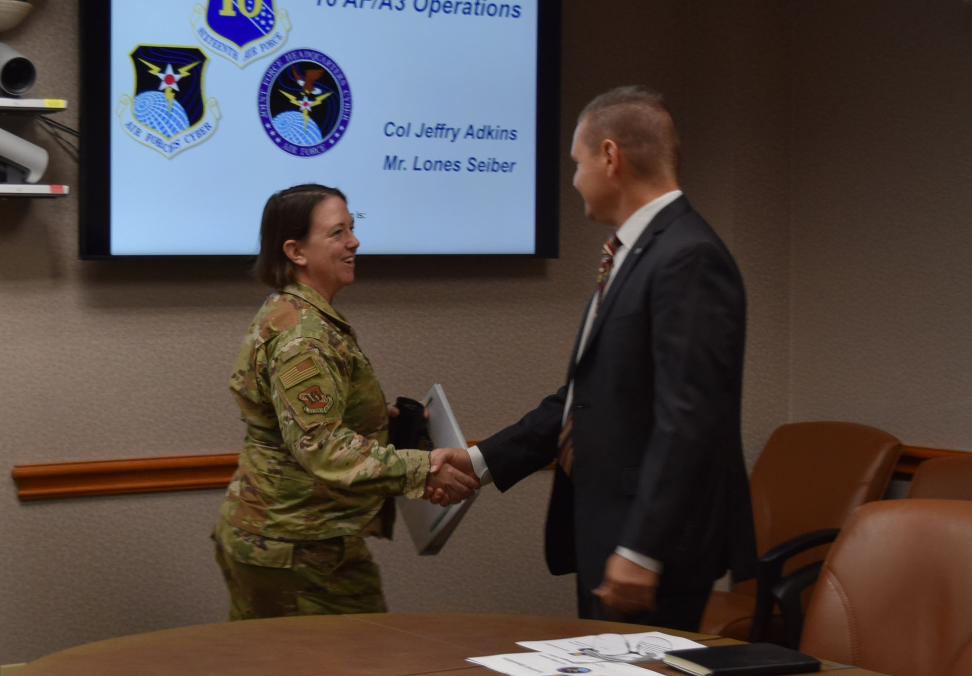 Brig. Gen. (Select) Melissa Stone shakes hands with a civilian.