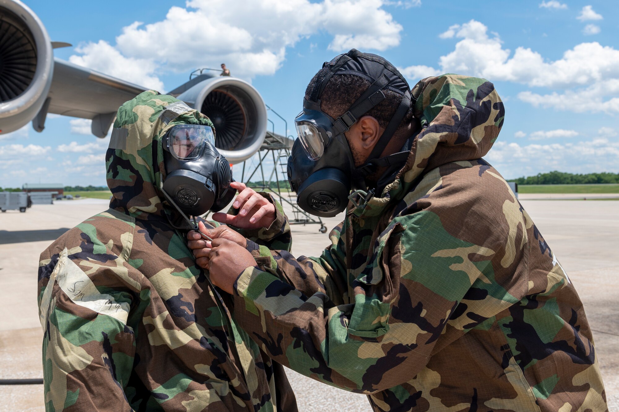U.S. Air Force Staff Sgt. Anthony Harris (left) and Senior Airman Thomas cook (right), maintainers with the 167th Maintenance Group, check each other’s gear during a simulated chemical environment training at the 167th Airlift Wing, Martinsburg, West Virginia, June 10, 2022. This training included maintainers, loadmasters, pilots and other personnel to simulate the process of preparing, loading and flying the aircraft while in a hazardous chemical environment