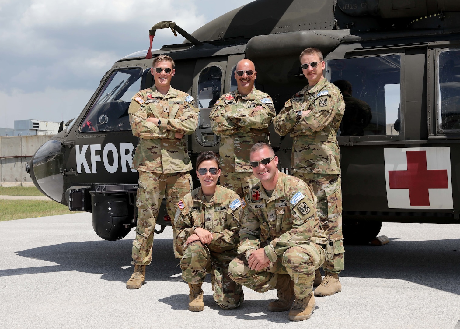 Left to right, back to front: U.S. Army Chief Warrant Officer 2 William Von Hemert, Chief Warrant Officer 4 Brady Lemmon, Sgt. Christopher Buchanan, Sgt. Ashley Camper and Staff Sgt. Nathaniel Moore, medevac crewmembers with Detachment 2, Charlie Company, 1st Battalion, 169th Aviation Regiment, Virginia National Guard, in front of their UH-60 Black Hawk helicopter at Camp Bondsteel, Kosovo, June 2, 2022. The team  evacuated two injured Albanian State Police officers from the mountainous region of northern Albania.