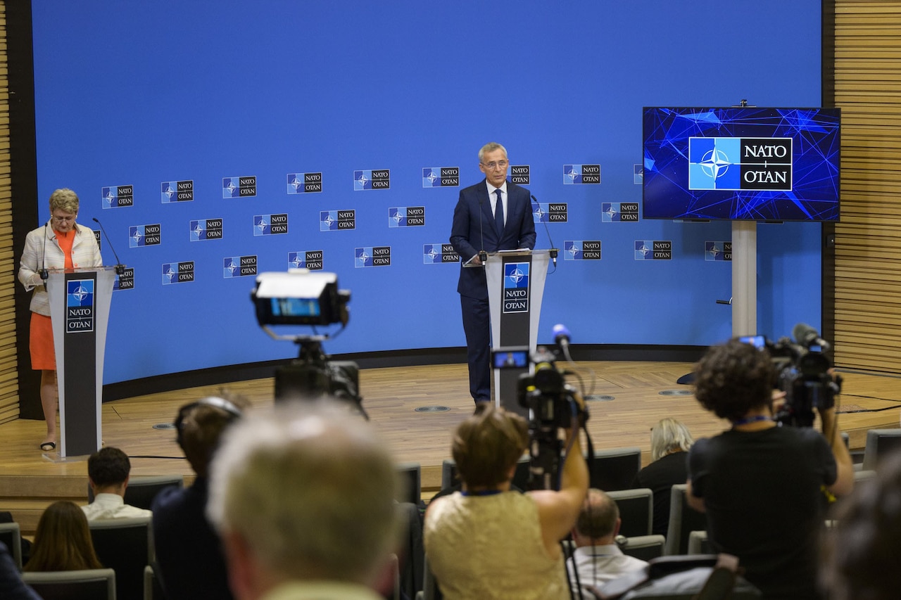 A man dressed in a business suit stands at a podium.