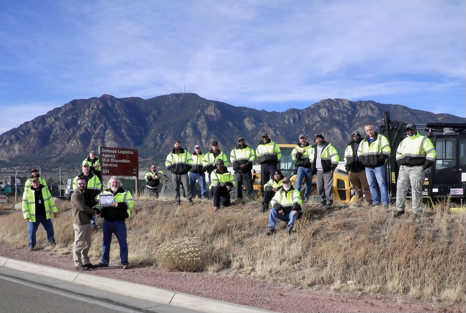 the team at DLA Disposition Services Colorado Springs sand outside in a lose group photo
