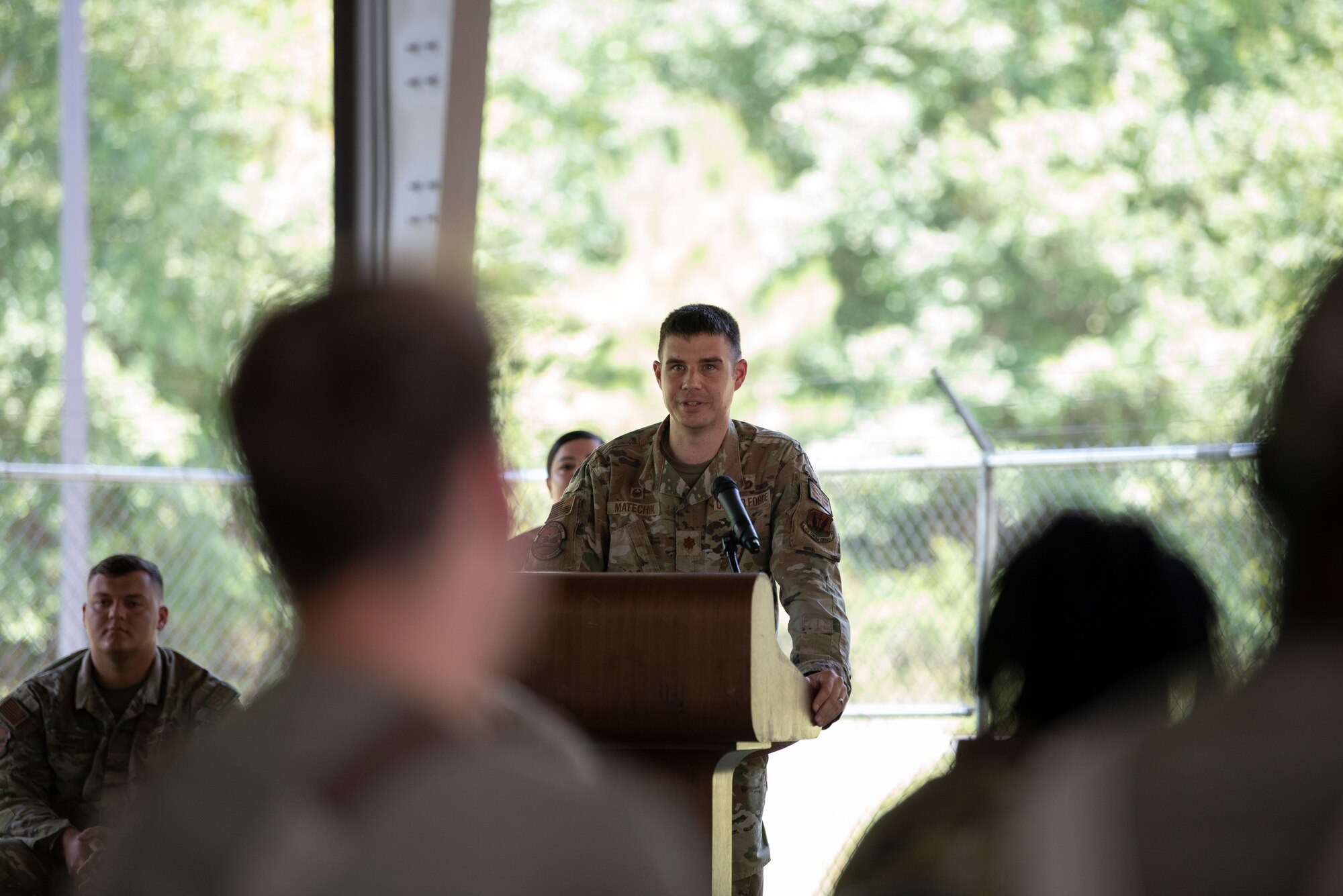 A photo of an Airman standing at a podium.