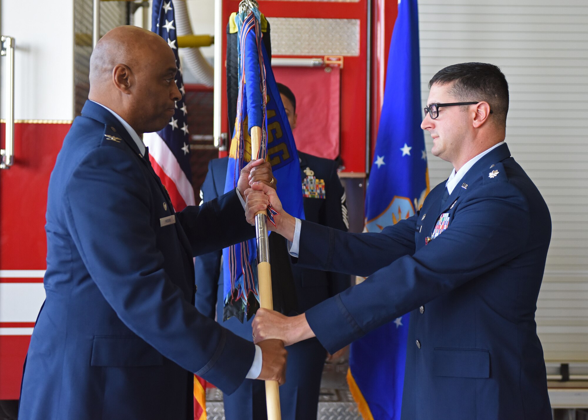 U.S. Air Force Lt. Col. Christopher Higgins, right, 17th Civil Engineer Squadron outgoing commander, relinquishes command to Col. Eugene Moore III, 17th Mission Support Group commander, during the 17th CES change of command ceremony at Goodfellow Air Force Base, Texas, June 17, 2022. Passing the guidon physically represents the symbolism of passing the squadron responsibilities to the next commander. (U.S. Air Force photo by Airman 1st Class Sarah Williams)