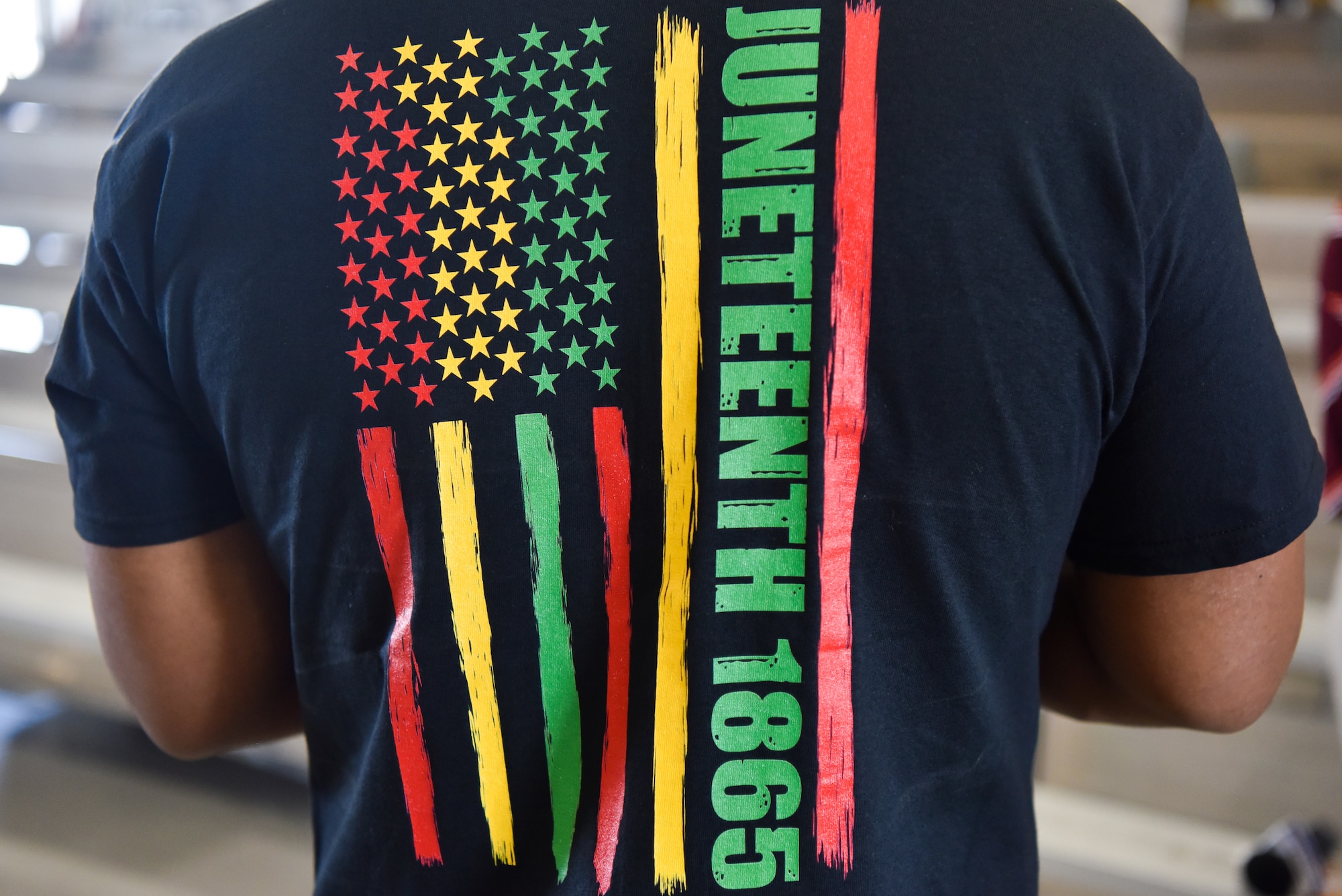 A Goodfellow member dons a Juneteenth shirt during the Juneteenth commemoration ceremony at Goodfellow Air Force Base, Texas, June 16, 2022. Juneteenth was established following the events of June 19, 1865, when Union General Gordon Granger arrived in Galveston, Texas and informed enslaved African Americans that the Civil War had ended and they were free. (U.S. Air Force photo by Staff Sgt. Jermaine Ayers)