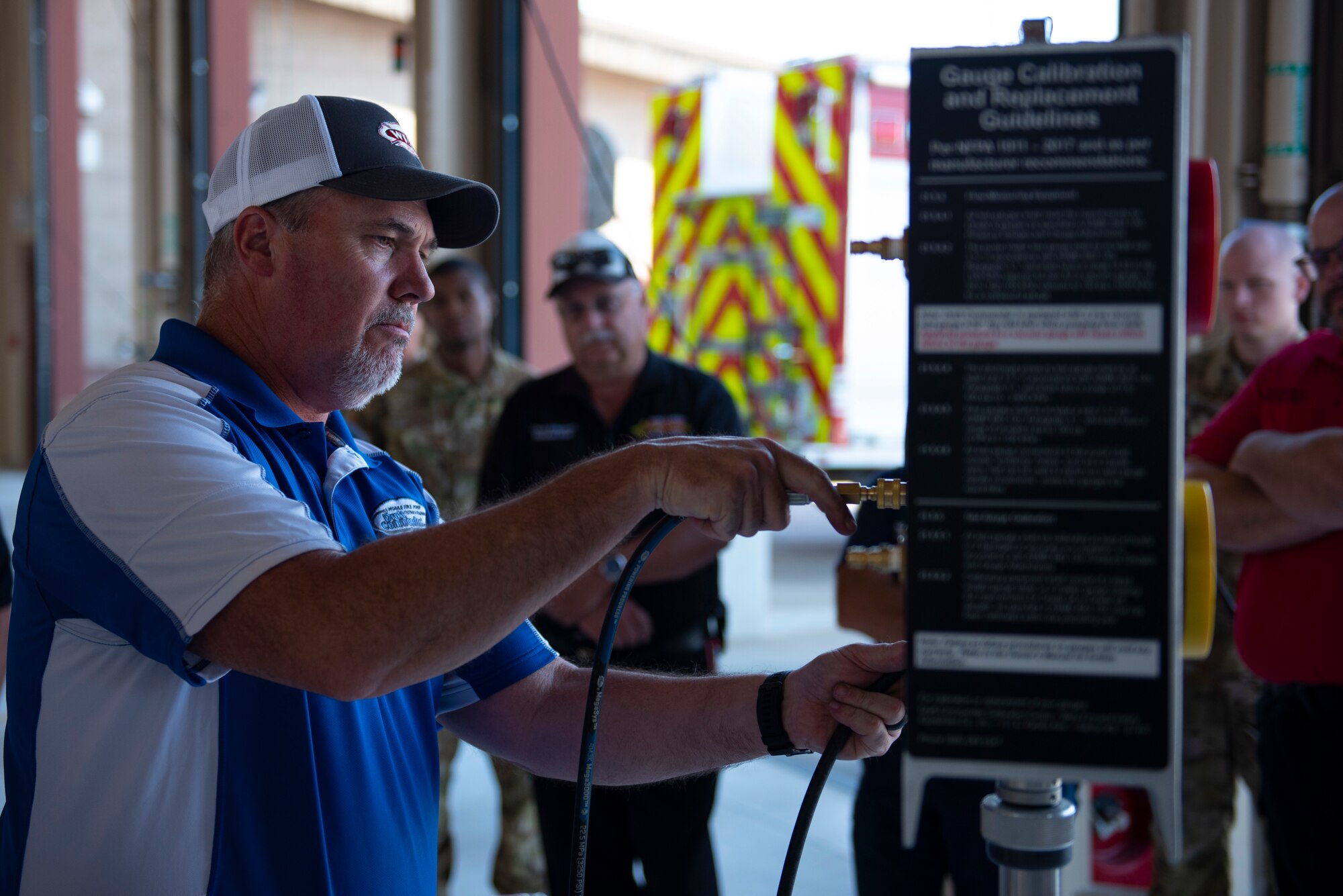 Steven Robertson, Draft Commander training and specialty technician, shows members of the 49th Civil Engineer Squadron on how to properly hook up lines to a master monitor, June 15, 2022, on Holloman Air Force Base, New Mexico.