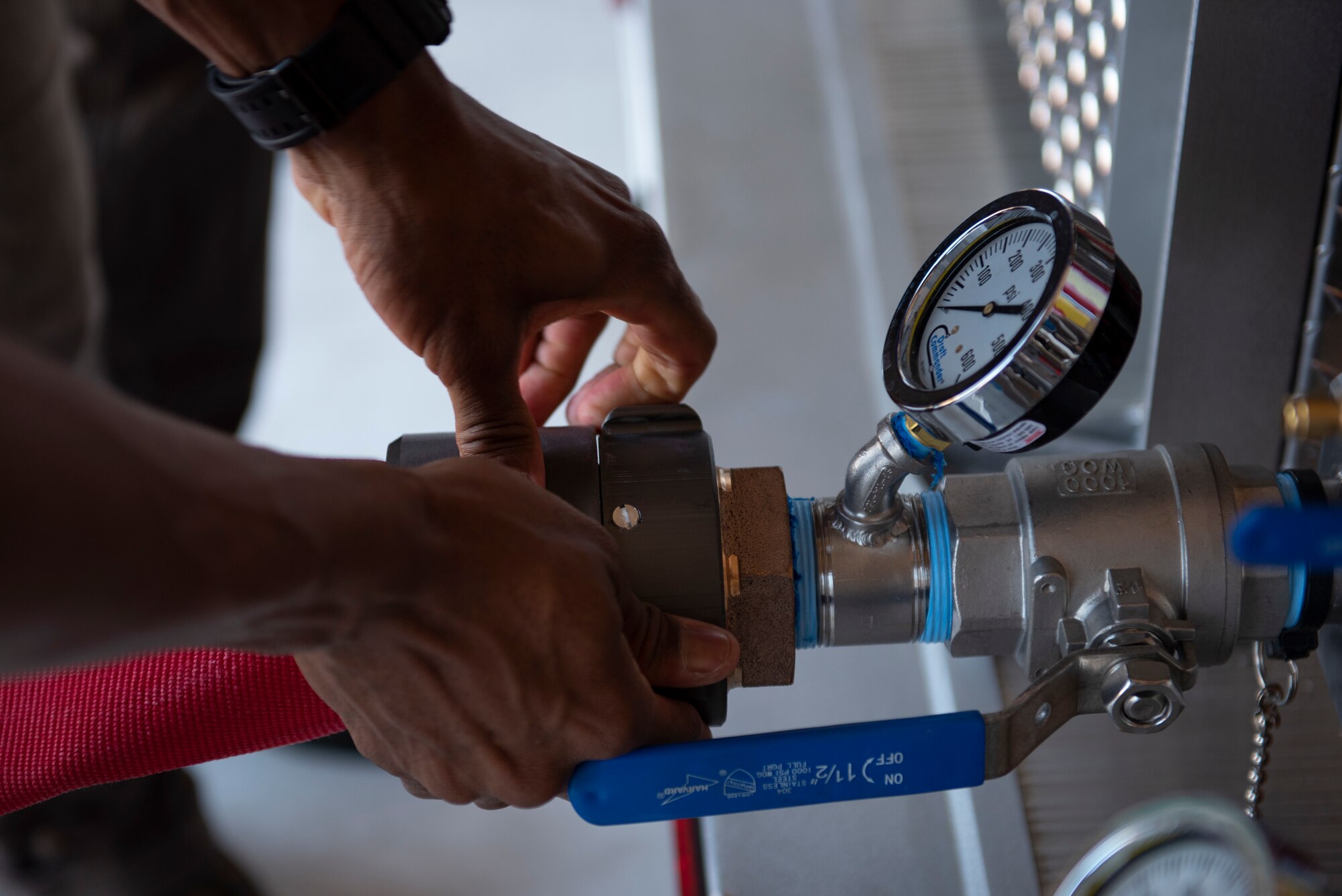 An Airman from the 49th Civil Engineer Squadron hooks up a discharge line to the Draft Commander system, June 15, 2022, on Holloman Air Force Base, New Mexico.