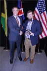Captain Christopher Hall, USN, Chief of Staff, National Maritime Intelligence-Integration Office, presenting a Maritime Domain Awareness Executive Steering Committee Excellence Award at the Law Enforcement Intelligence Unit/International Association of Law Enforcement Intelligence Analysts (LEIU/IALEA) in Dallas, TX, April 2022.