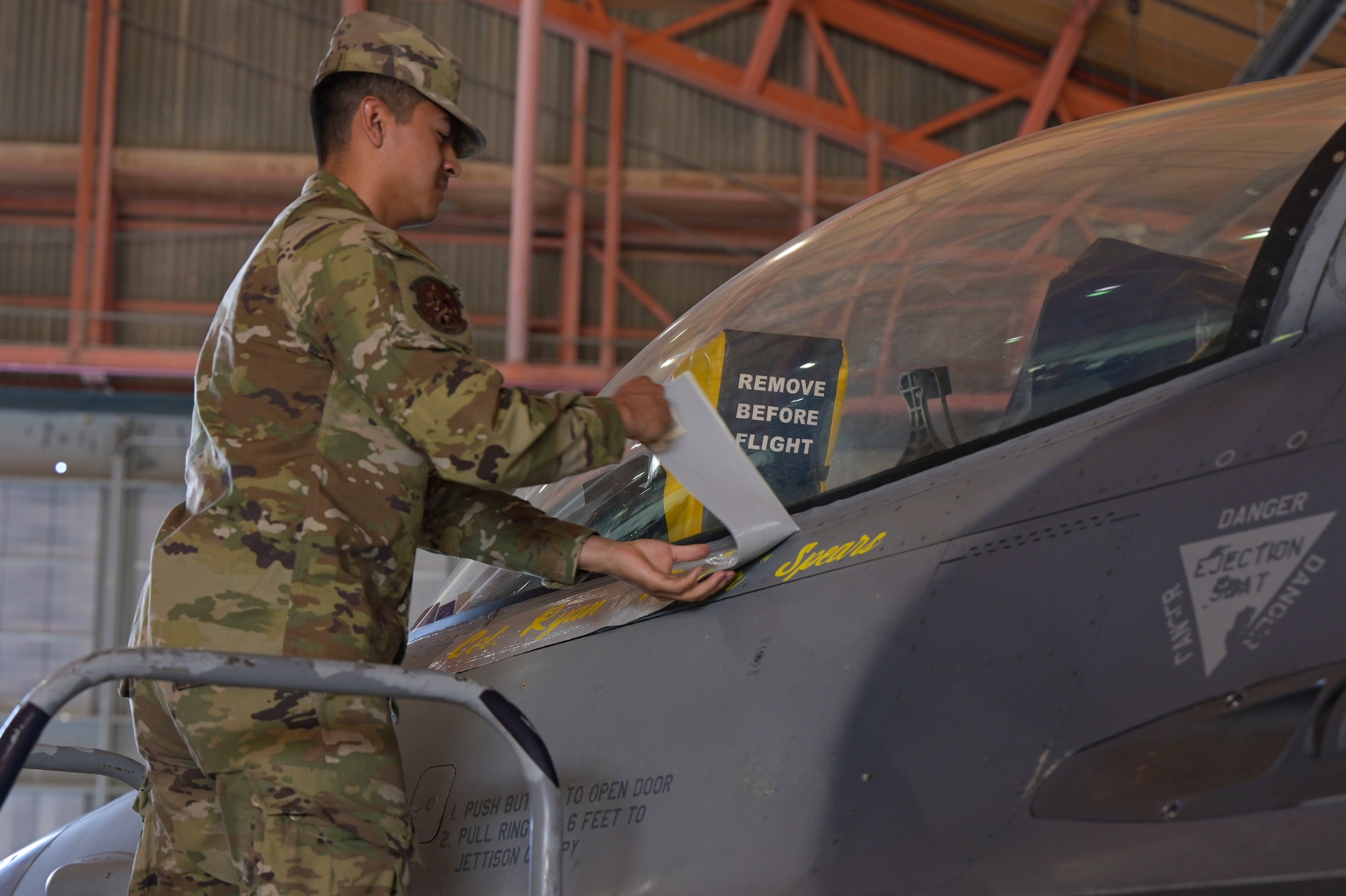 Senior Airman Tristen Estrada, 849th Aircraft Maintenance Squadron assistant dedicated crew chief, unveils the name of Col. Justin B. Spears, 49th Wing commander, on the 49th Wing F-16 Viper flagship, June 17, 2022, on Holloman Air Force Base, New Mexico. Traditionally, the 49th Wing flagship bears the name of the current Wing Commander. (U.S. Air Force photo by Airman 1st Class Antonio Salfran)