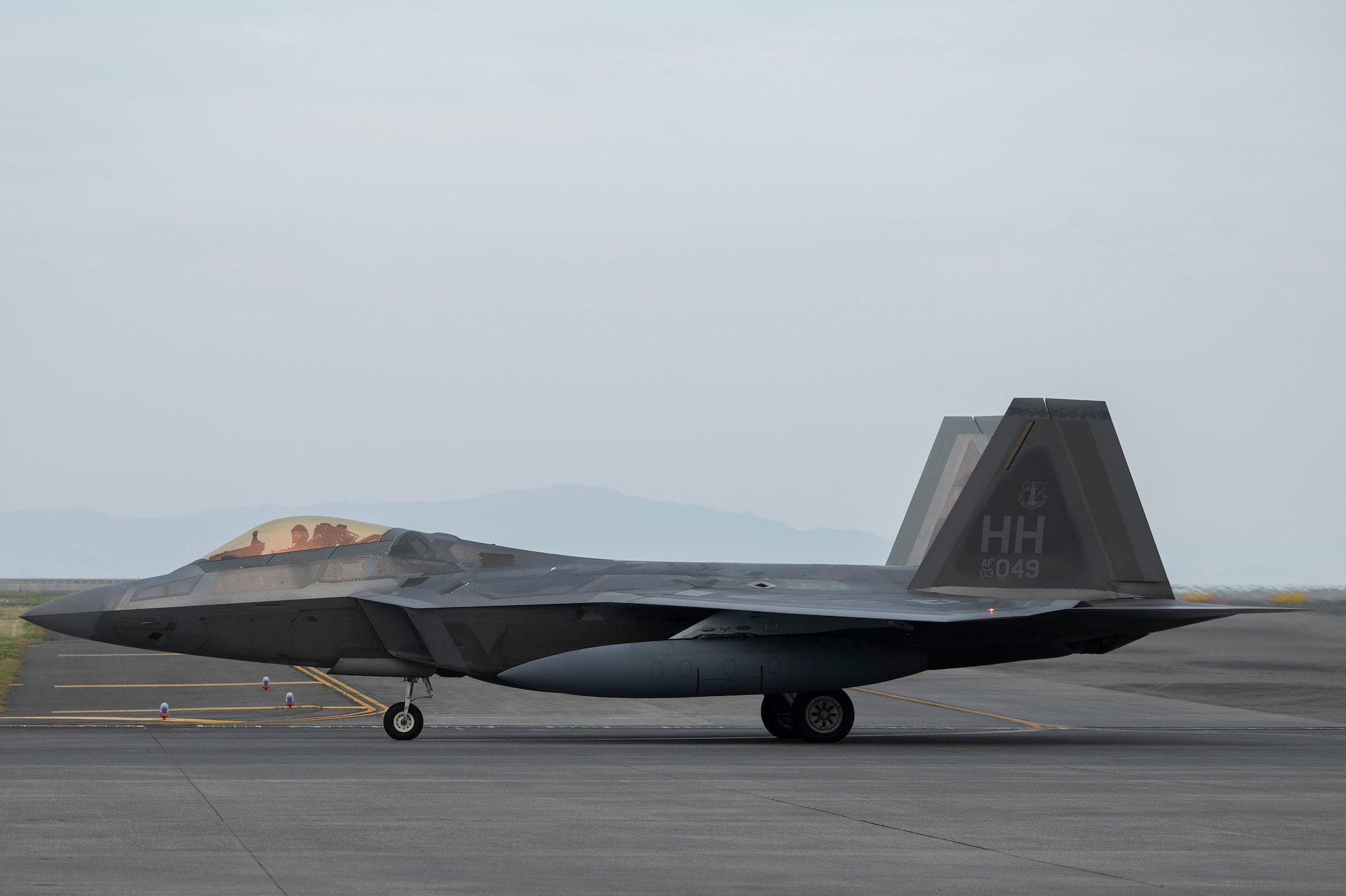 A U.S. Air Force F-22 Raptor assigned to the 199th Expeditionary Fighter Squadron taxis on the runway upon arrival to an agile combat employment training event at Marine Corps Air Station Iwakuni, Japan, June 15, 2022. During the ACE training event, the 199th EFS is assigned to the 354th Air Expeditionary Wing and operating with the 356th Expeditionary Fighter Squadron to refine fifth generation integration tactics, techniques and procedures. (U.S. Air Force photo by Staff Sgt. Zade Vadnais)