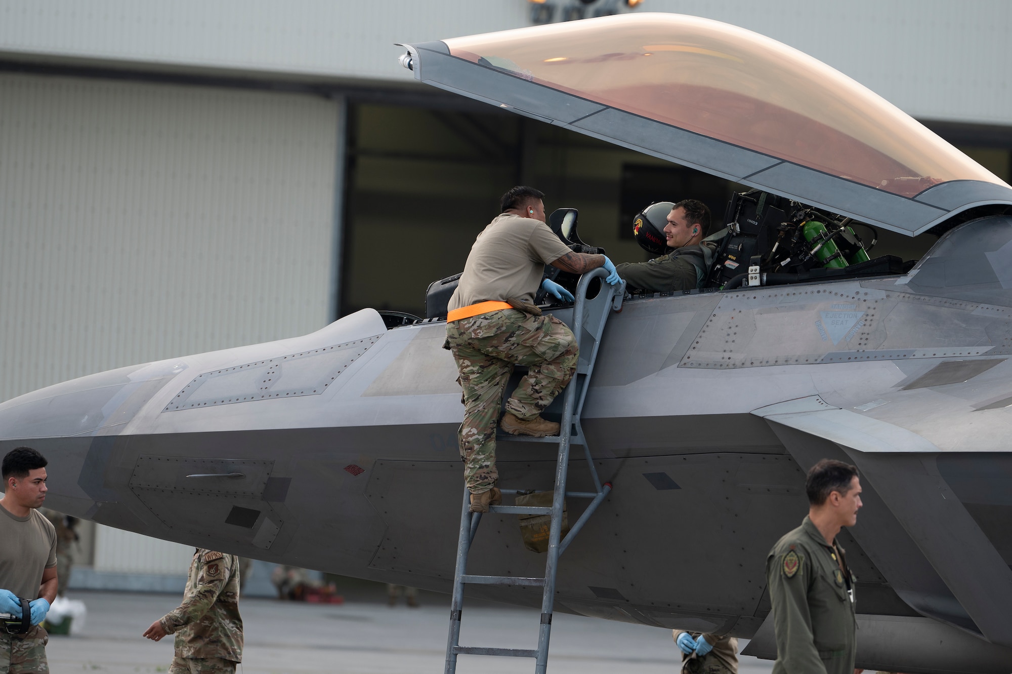 A U.S. Airman assigned to the 354th Air Expeditionary Wing greets a pilot assigned to the 199th Expeditionary Fighter Squadron upon arrival to an agile combat employment training event at Marine Corps Air Station Iwakuni, Japan, June 15, 2022. During the ACE training event, the 199th EFS is assigned to the 354th Air Expeditionary Wing and operating with the 356th Expeditionary Fighter Squadron to refine fifth generation integration tactics, techniques and procedures. (U.S. Air Force photo by Staff Sgt. Zade Vadnais)