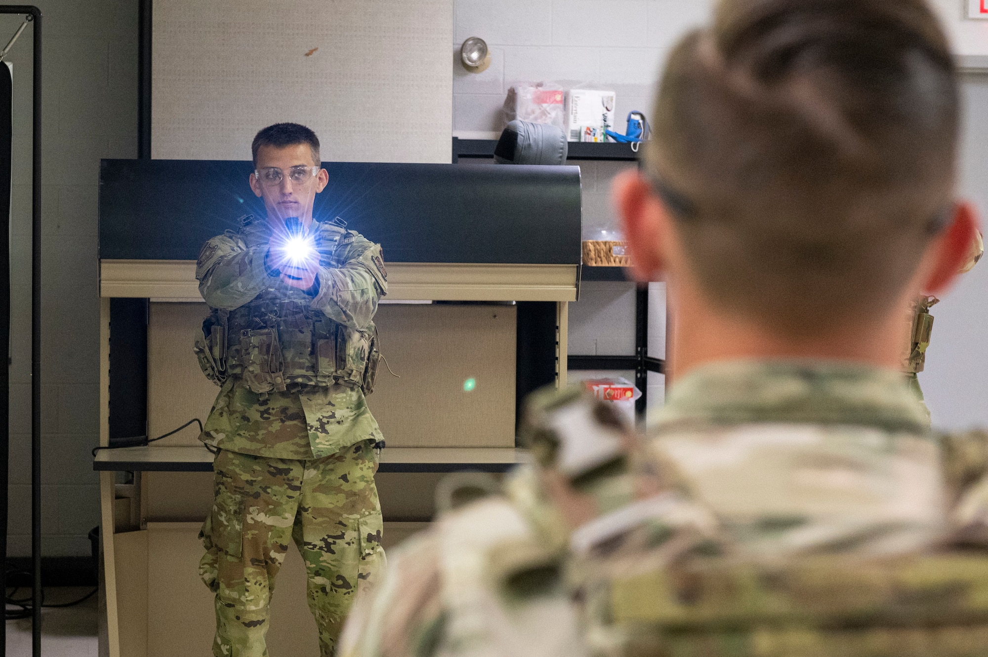 U.S. Air Force Airman 1st Class Dylan Ramsey, a defender with the 167th Security Forces Squadron, aims a trainer taser as part of a mock taser deployment training during June’s unit training assembly at the 167th Airlift Wing, Martinsburg, West Virginia, June 10, 2022. Trainings like these allow security forces personnel to become more familiar with their weapon platforms and practice using non-lethal force.