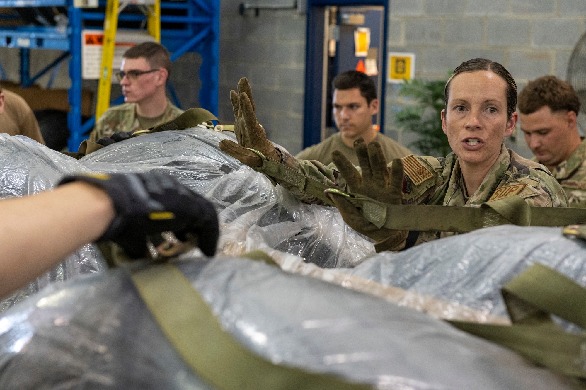 U.S. Air Force Staff Sgt. Summer Willson, a supply technician with 167th Logistics Readiness Squadron, secures a webbing strap during a pallet training event at the 167th Airlift Wing, Martinsburg, West Virginia, June 9, 2022. Building pallets like these are essential to quickly and safely load and unload U.S. Air Force cargo aircraft.