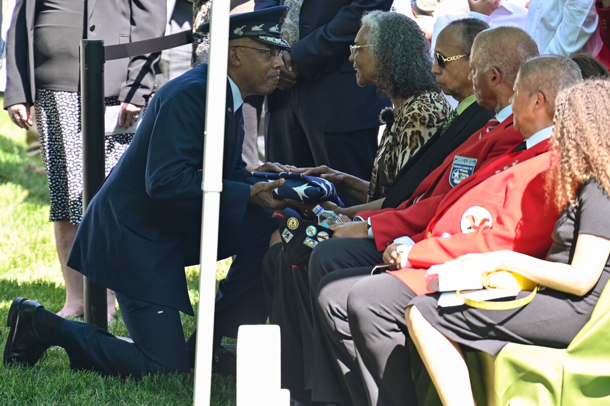 Air Force Chief of Staff Gen. CQ Brown, Jr. presents the American flag to Charlene McGee Smith, the daughter of Brig. Gen. Charles E. McGee, during his funeral at Arlington National Cemetery, Arlington, Va., June 17, 2022. McGee, a Tuskegee Airman, died Jan. 16, 2022 at the age of 102. He served 30 years during World War II, the Korean War and the Vietnam War. (U.S. Air Force photo by Eric Dietrich)