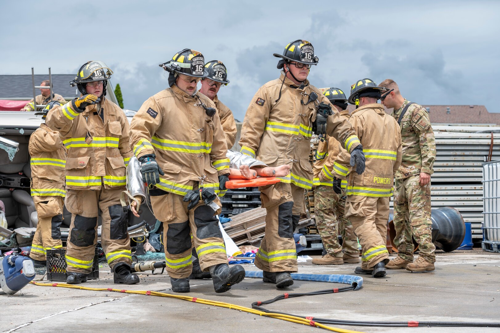 Firefighters with the 167th Airlift Wing carry a simulated patient on a stretcher for medical care after rescuing the victim from a vehicle accident during a vehicle extrication exercise at the 167th Airlift Wing, Martinsburg, West Virginia, June 11, 2022. The training exercise involved the response and rescue of a trapped victim in a vehicle accident.