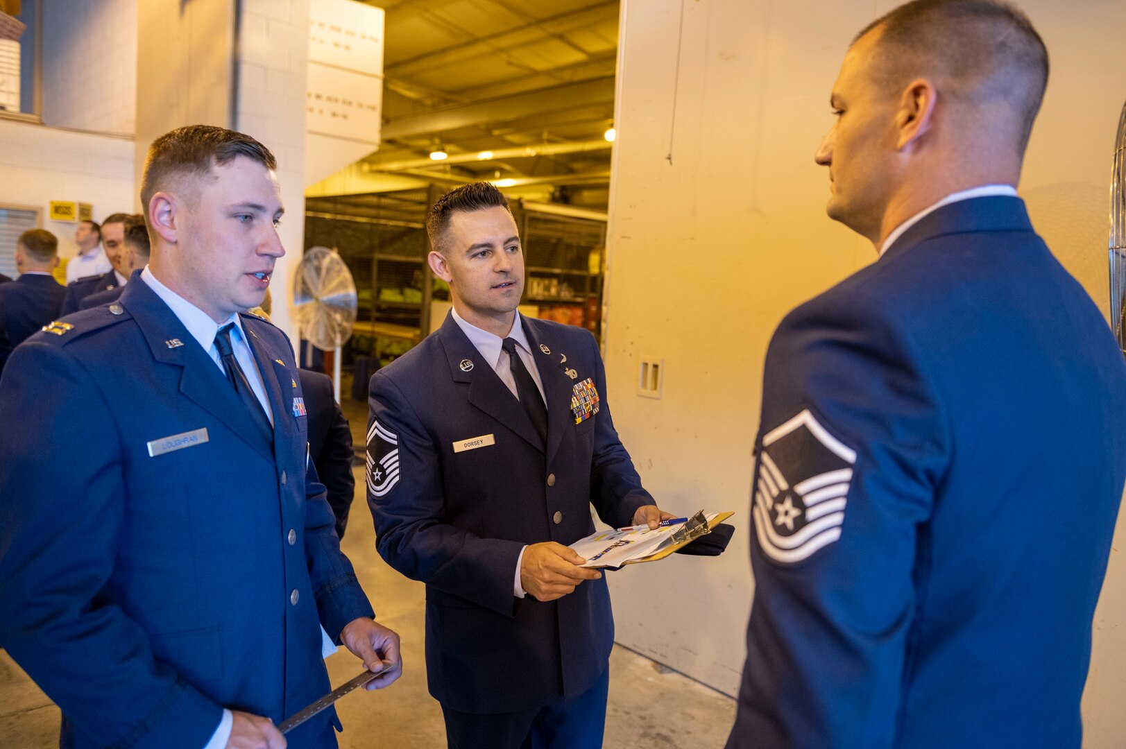 U.S. Air Force Capt. Timothy Loughran, 167th installation deployment officer and Senior Master Sgt. Chad Dorsey, 167th logistics plans and integration superintendent, inspect Master Sgt. Josh Clark, during an open ranks inspection of the deployment and distribution flight at the 167th Airlift Wing, Martinsburg, West Virginia, June 11, 2022. During an open ranks uniform inspection, the service member’s uniform is meticulously examined to ensure adherence to uniform standards.
