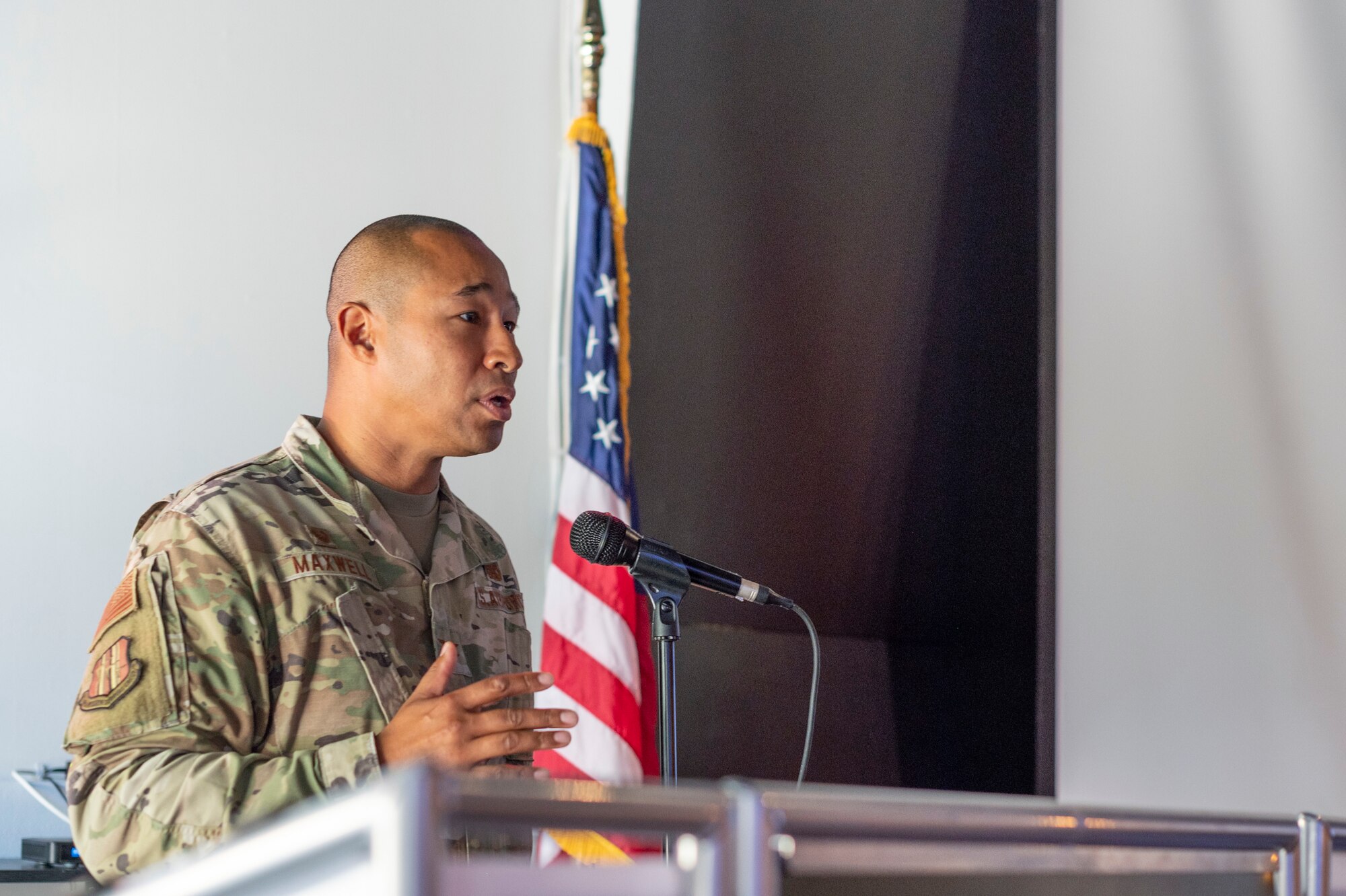 An Airman speaks at a podium.