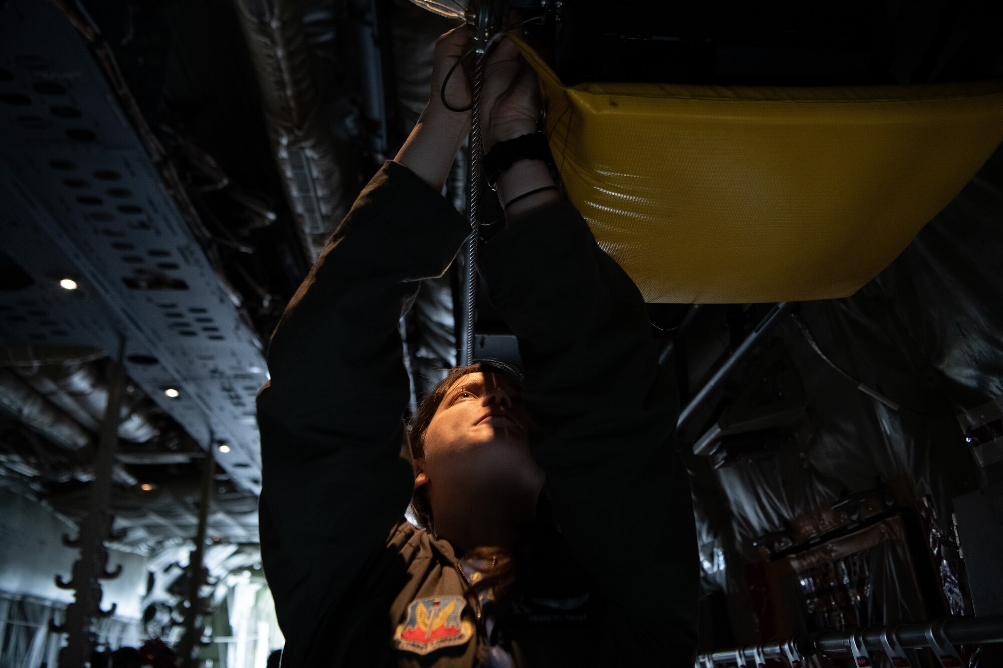 An Airman secures cargo in the back of a plane.