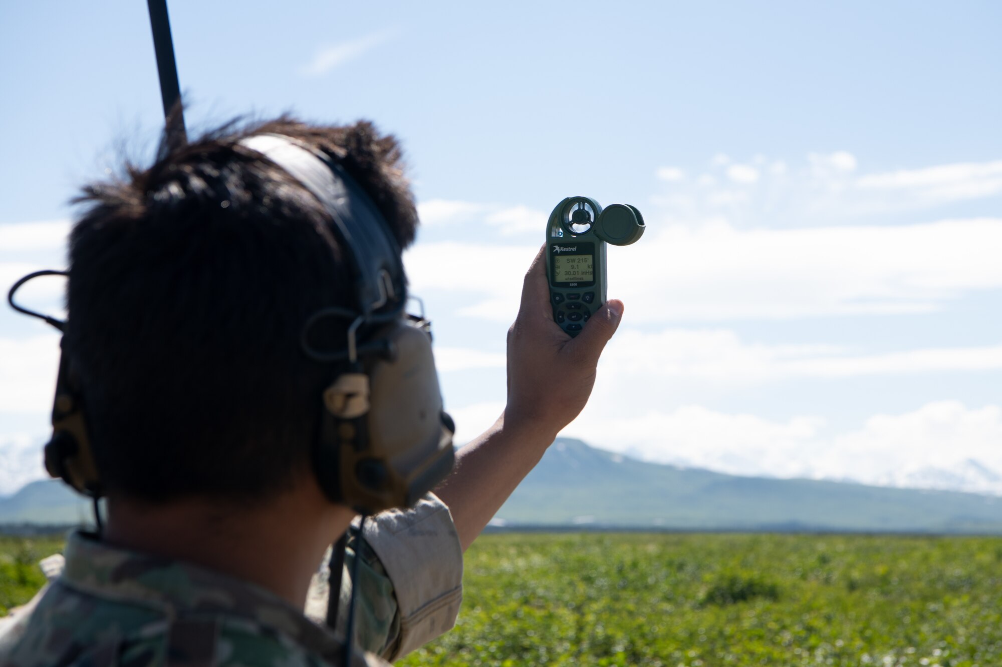 An Airmen checks wind speed using a handheld device.