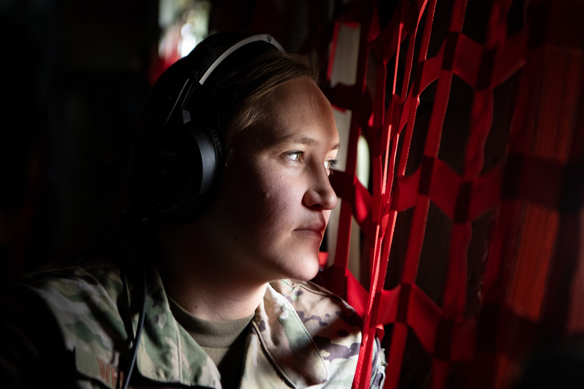 An Airmen looks out of a window on a C-130.