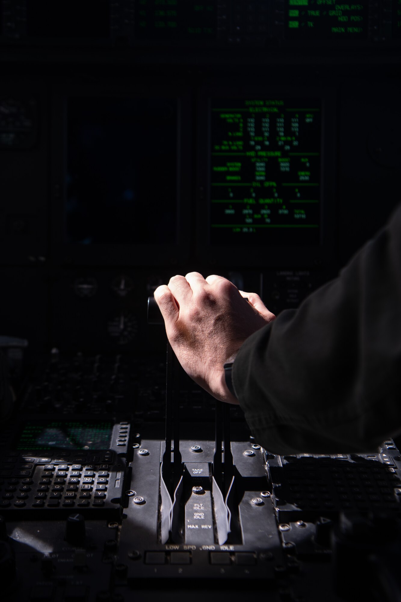 A hand pushes up on the throttle of a C-130.