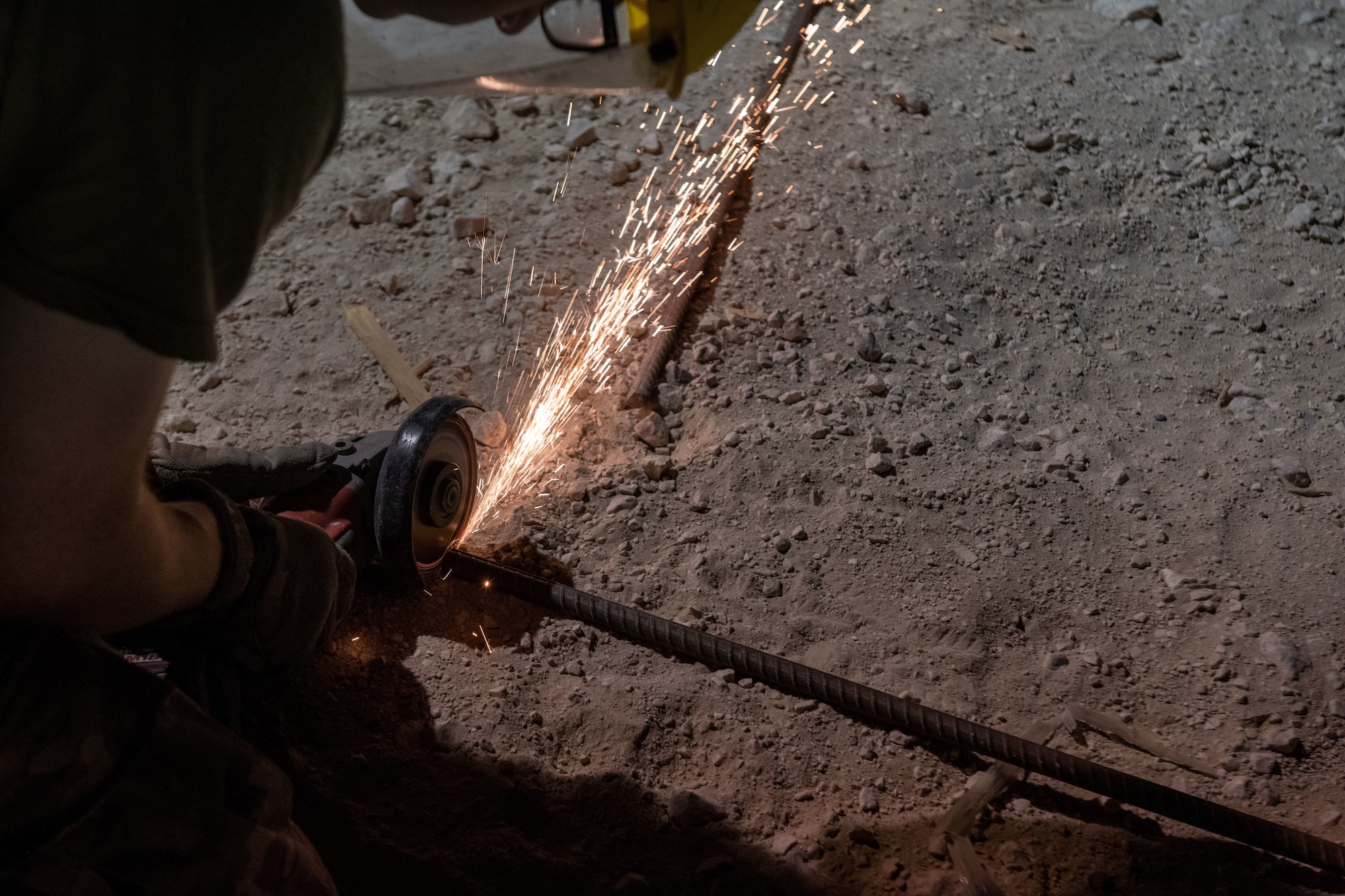U.S. Air Force Senior Airman Ethan King, a civil engineer with the 1st Expeditionary Civil Engineer Group, cuts rebar during a construction project on Al Udeid Air Base, Qatar, June 17, 2022. Rebar is used to reinforce concrete when constructing buildings. (U.S. Air National Guard photo by Airman 1st Class Constantine Bambakidis)