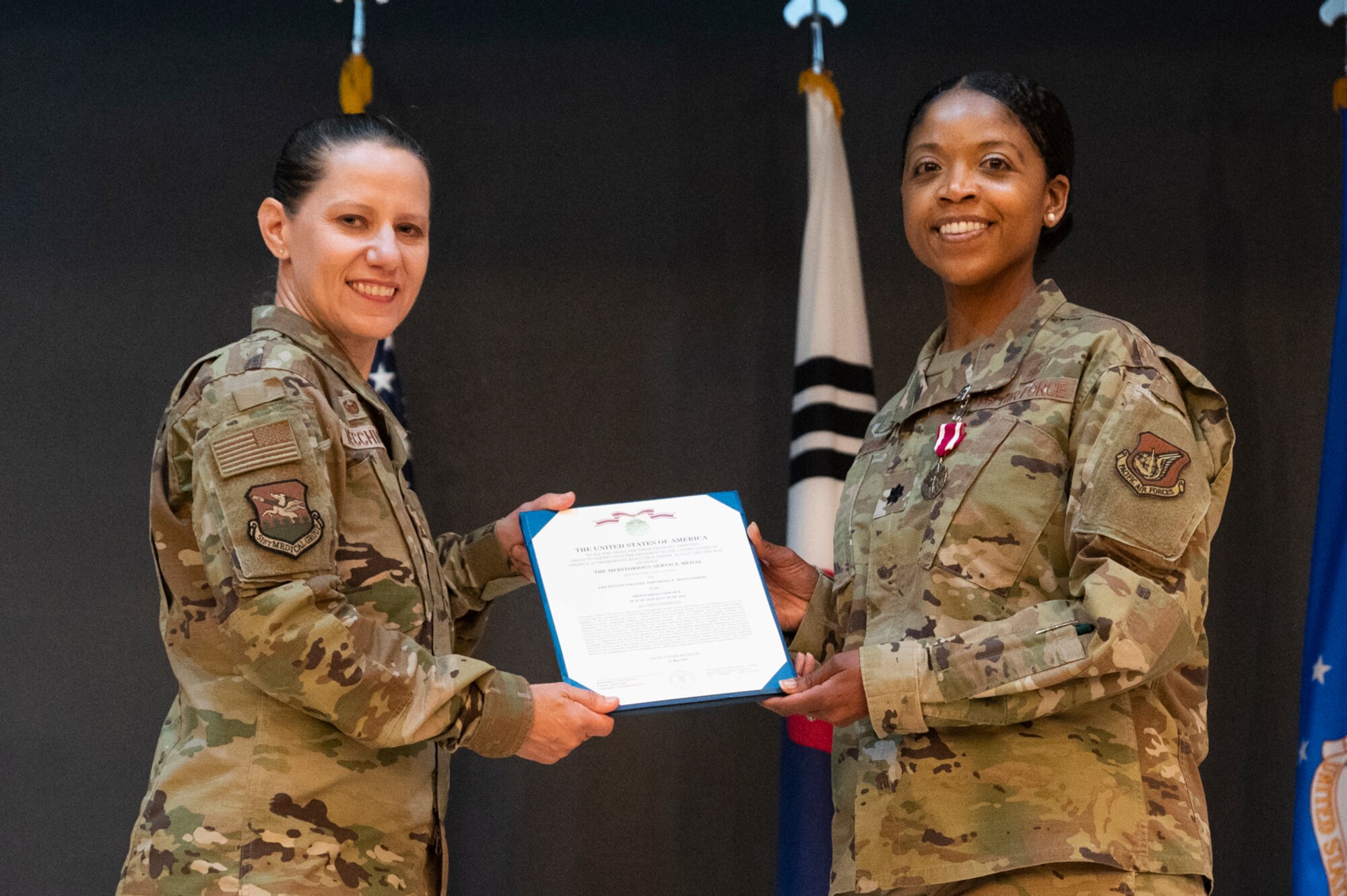 Col. Jennifer Vecchione, left, 51st Medical Group commander, presents Lt. Col. Theodosia Montgomery, 51st Medical Support Squadron (MDSS) outgoing commander, a Meritorious Service Medal (MSM) medal